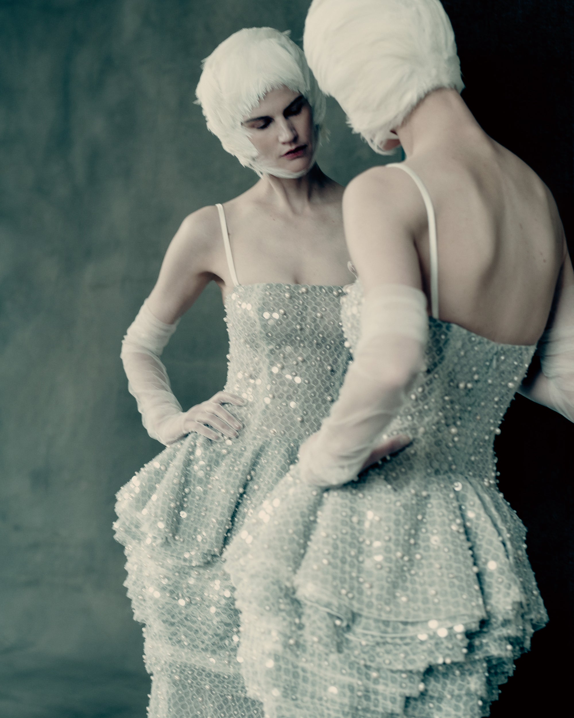 Pegged column gown with tiered peplum skirt and delicate spaghetti straps. Cascading layers of soft tulle, silk organza, and honeycomb lace are delicately hand-embroidered with genuine baroque pearls and transparent sequins. Soft internal bobbinete bustier, grosgrain waistbelt, and invisible zip closure at center back. 