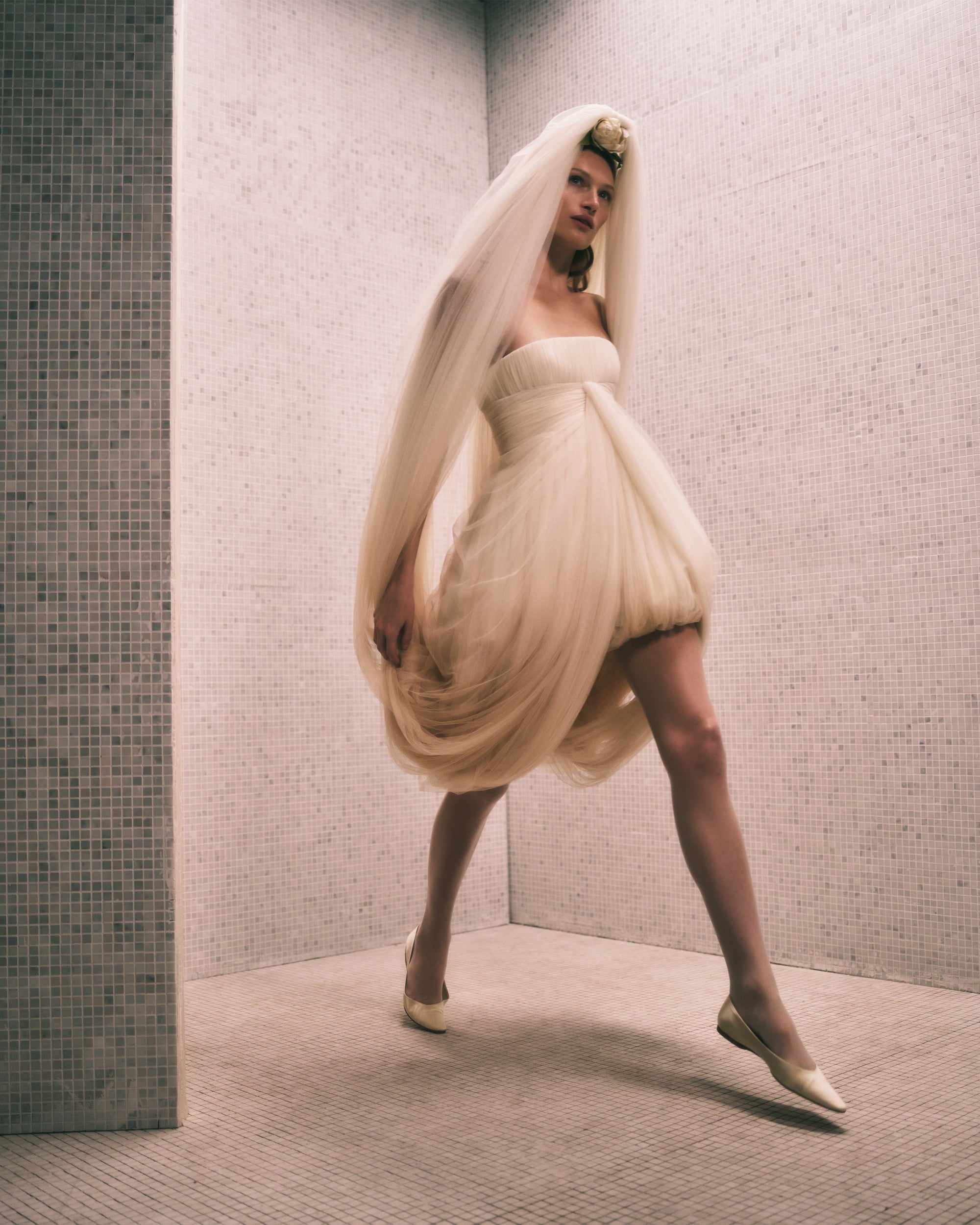 Dip dyed soft tulle mini dress with draped veil cascading from head and looping into mini skirt. Layers of soft tulle drape the bodice and fall into an asymmetrical bubble hem. Boned internal bustier, internal grosgrain belt and invisible zip closure at center back.