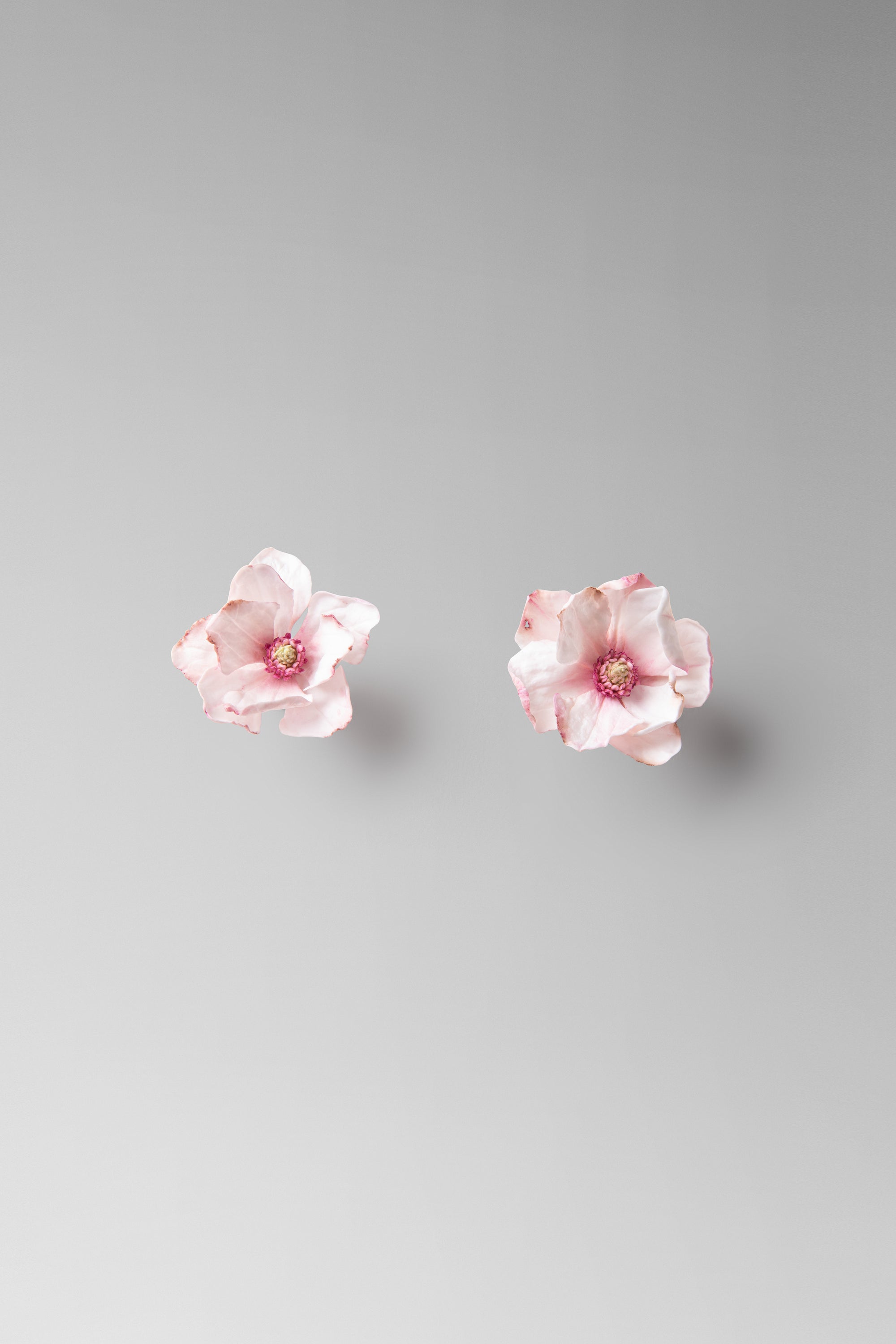 Individually hand shaped and painted clay flowers. Feather weight with sterling silver post back finishing.Approximate measure: H: 1 1/2 ” x W: 1 1/4”Due to the hand made nature of the individual petals as well as the asymmetrical design of the pair, each piece will vary slightly in size. 