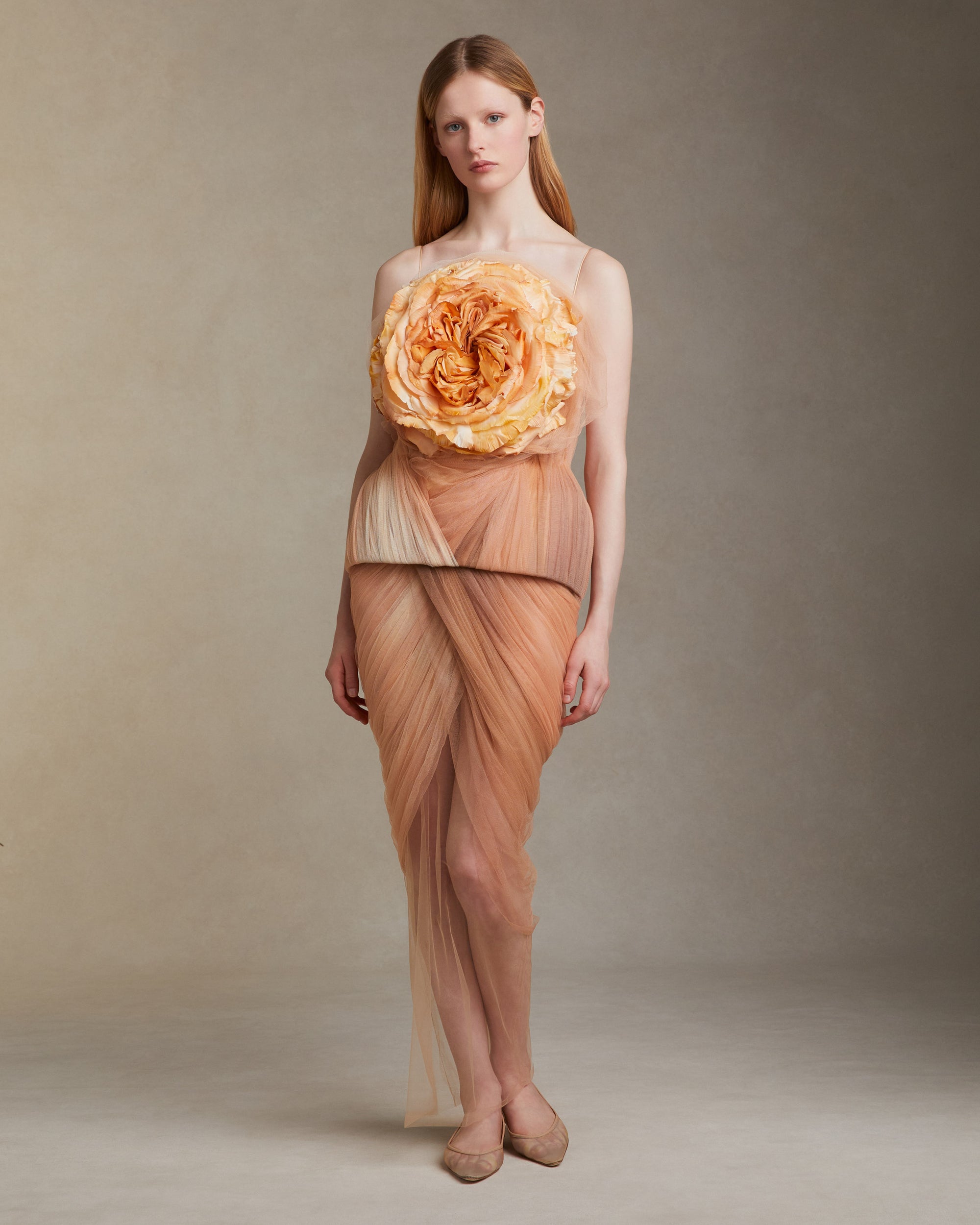 Hand dyed ombre soft tulle bustier with nipped waist and structured hip shape. A hand crafted clay rose blooms from layers of soft tulle at bust. Separating zipper closure at center back.