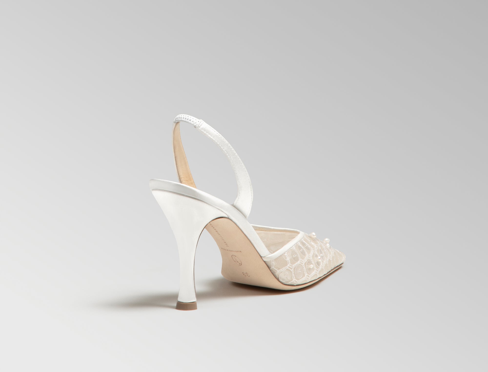 Mesh slingback with trellis thread embroidery embellished in transparent sequins and natural pearls. Elongated round toe, leather and satin detailing, 90mm heel. Hand crafted in Italy.