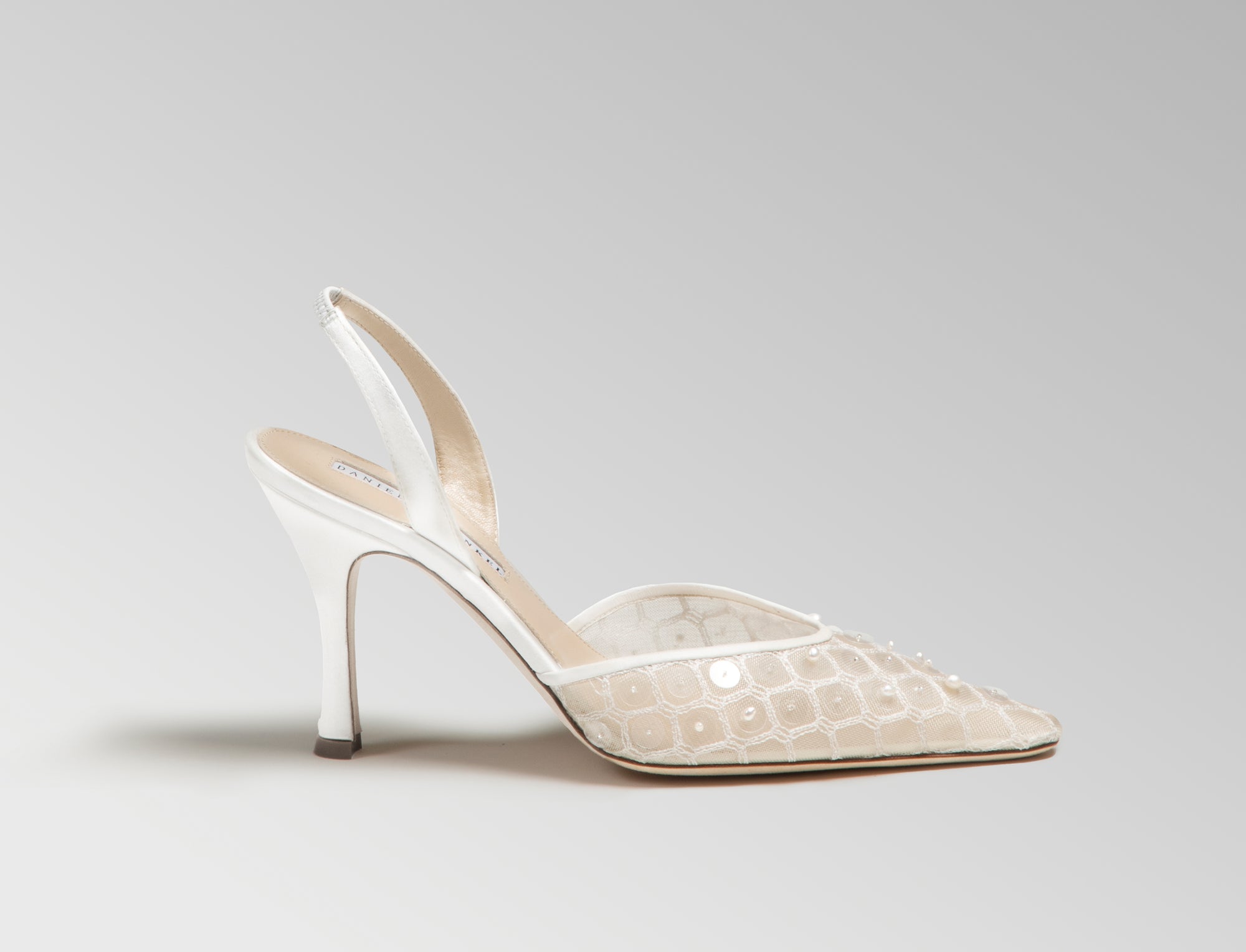 Mesh slingback with trellis thread embroidery embellished in transparent sequins and natural pearls. Elongated round toe, leather and satin detailing, 90mm heel. Hand crafted in Italy.