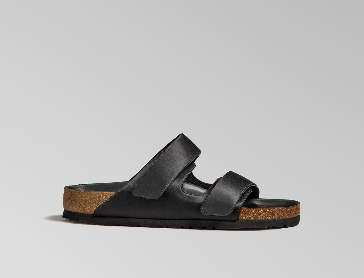 The Arizona takes a sleek turn in black satin, offering a modern, unisex design perfect for any elegant event. The design also introduces an innovative adjustable hidden buckle closure. Expertly crafted in Germany, the shoe pairs the signature BIRKENSTOCK comfort with understated sophistication through Danielle Frankel design touch. - Upper: Delicate satin upper, piped trim edge detail for premium tuxedo like finish- Footbed: Anatomical shaped BIRKENSTOCK cork latex Footbed lined with premium Nappa Leather- Sole: EVA die cut outsole with a custom design, blending classic BIRKENSTOCK bone pattern with delicate leaf inspired detailing 