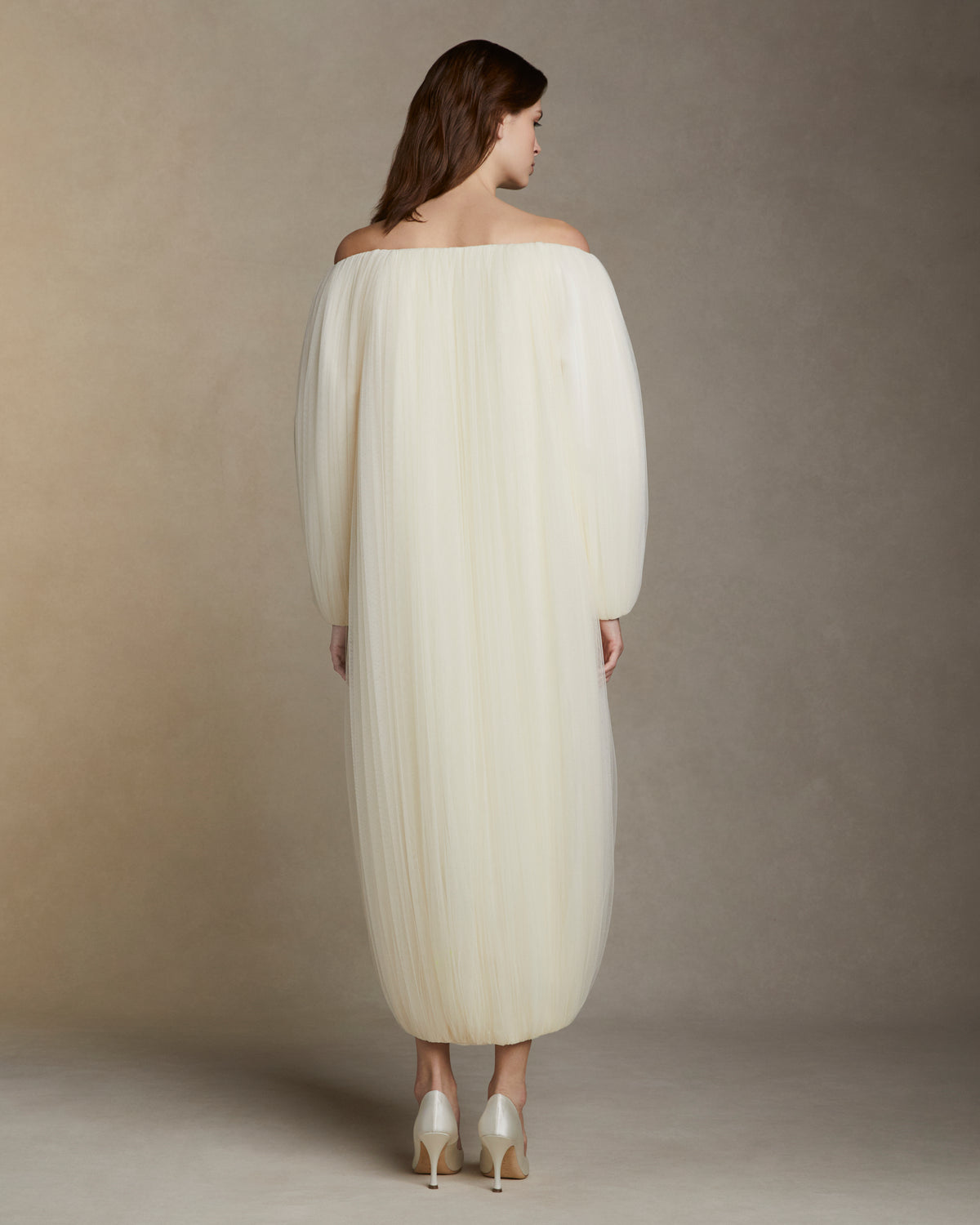 Draped soft tulle off the shoulder cocoon coat. Hook and eye closure at center front.