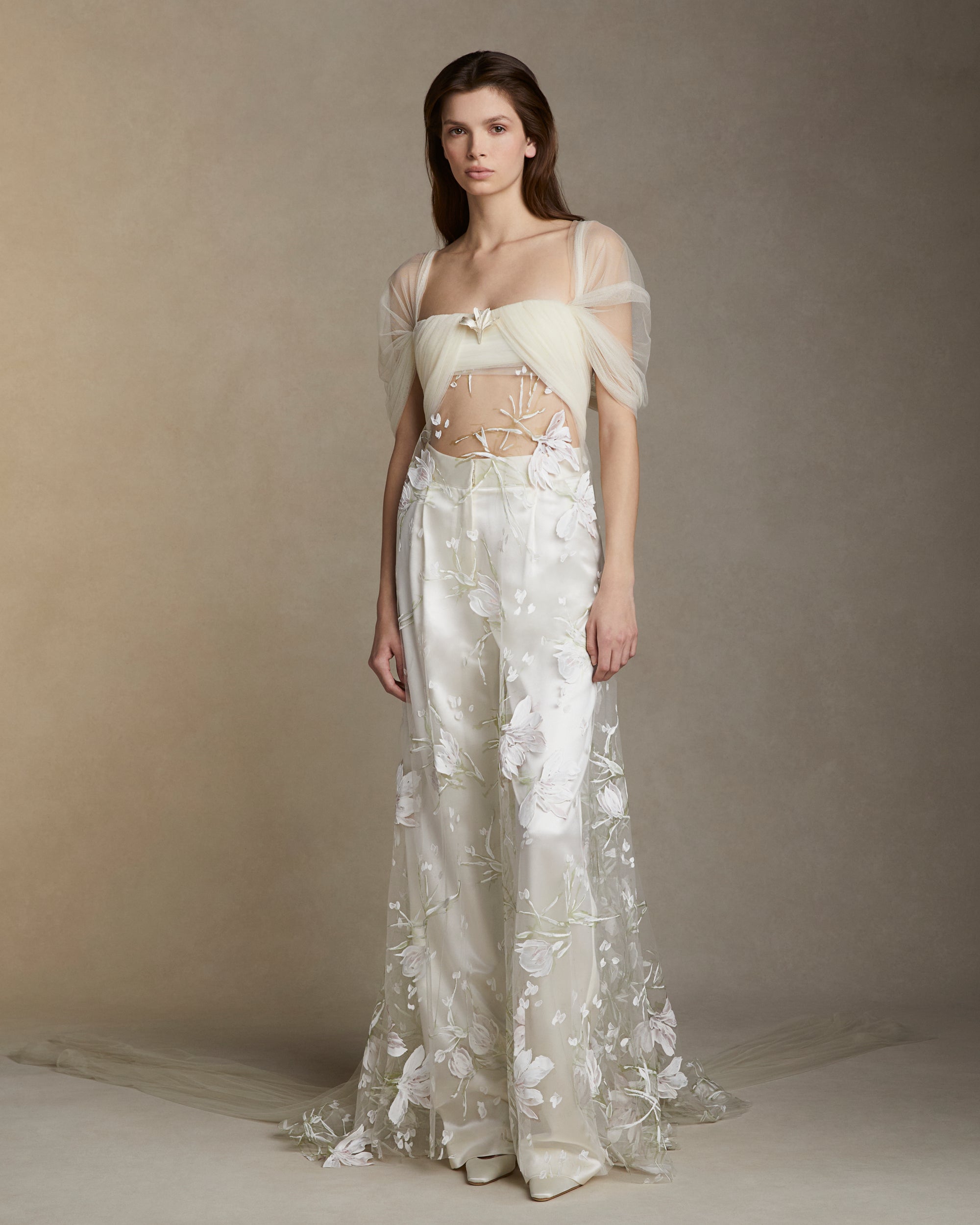 Draped soft tulle bodice with swagged sleeve and hand painted floral illusion tulle overlay.Sterling silver floral tulip accessory styled at bust sold separately.