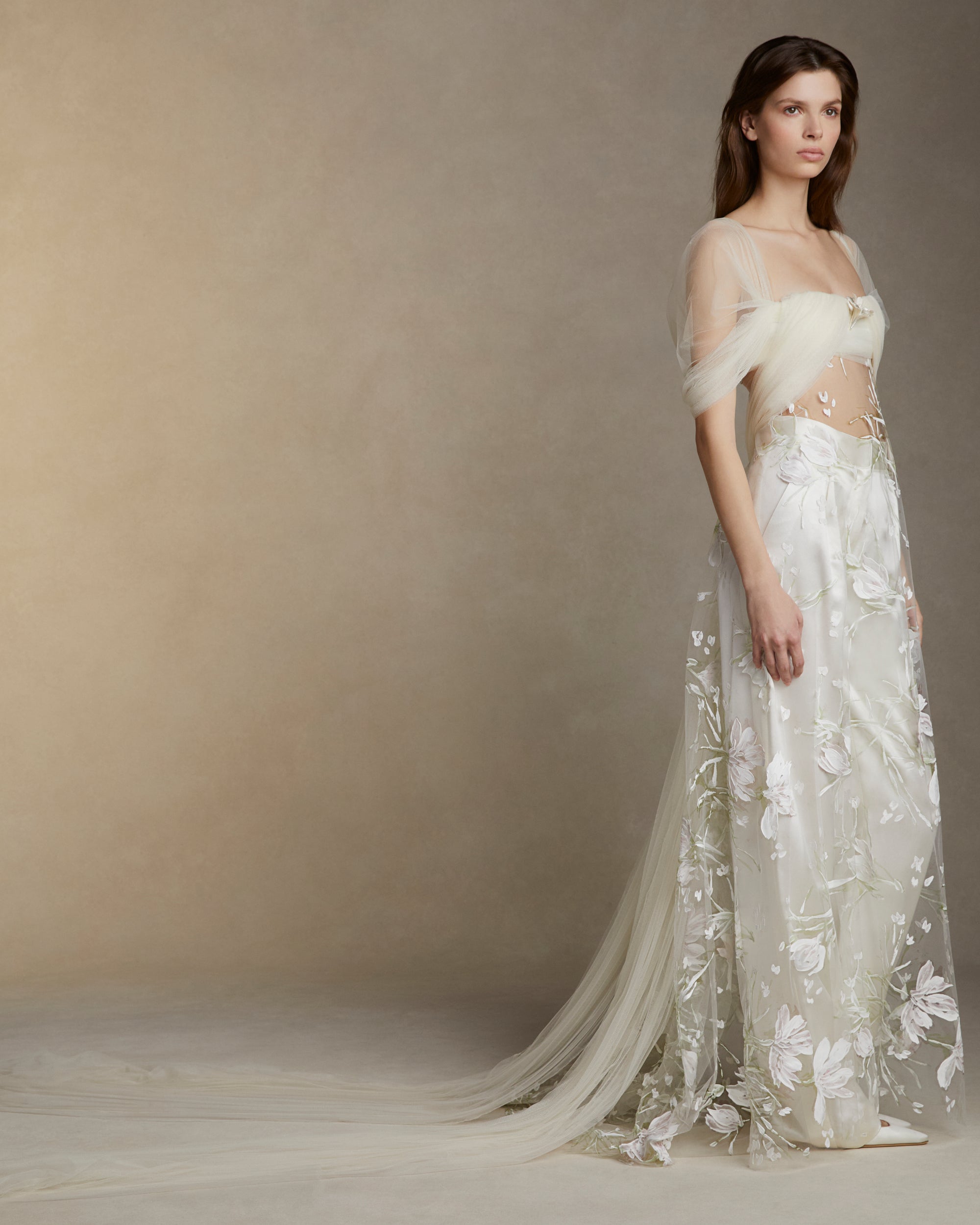 Draped soft tulle bodice with swagged sleeve and hand painted floral illusion tulle overlay.Sterling silver floral tulip accessory styled at bust sold separately.