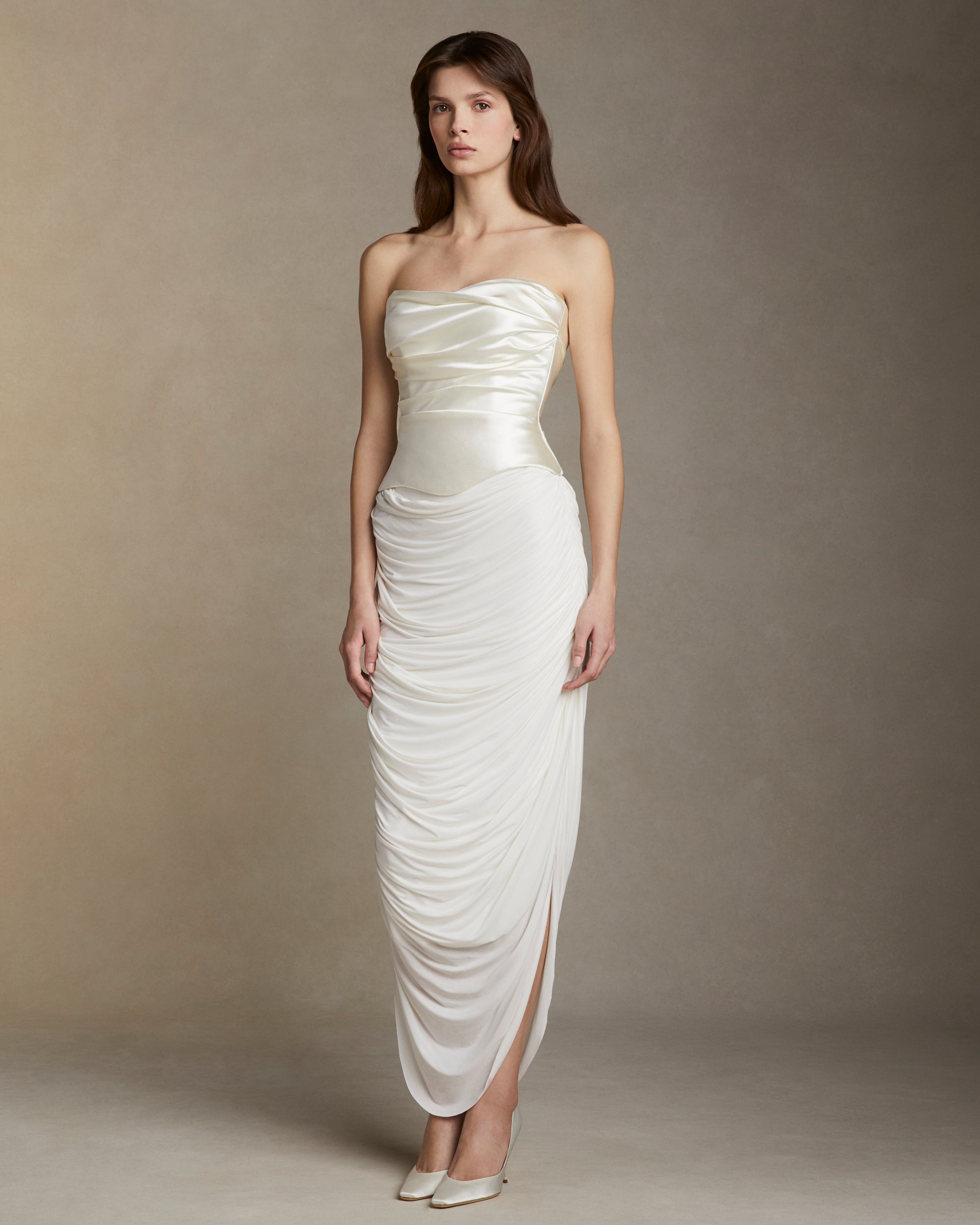 Fluid jersey skirt with cascading drape and side slits. Invisible zip closure at side.Styled with Demi﻿ bustier