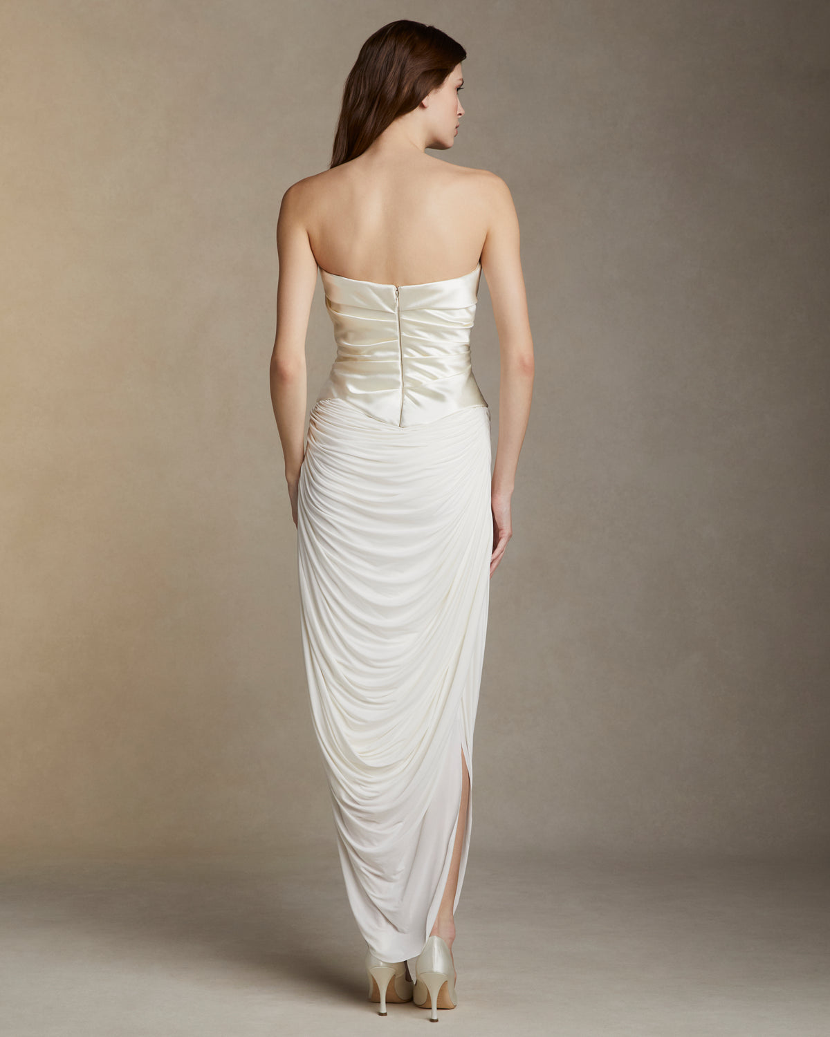 Fluid jersey skirt with cascading drape and side slits. Invisible zip closure at side.Styled with Demi﻿ bustier