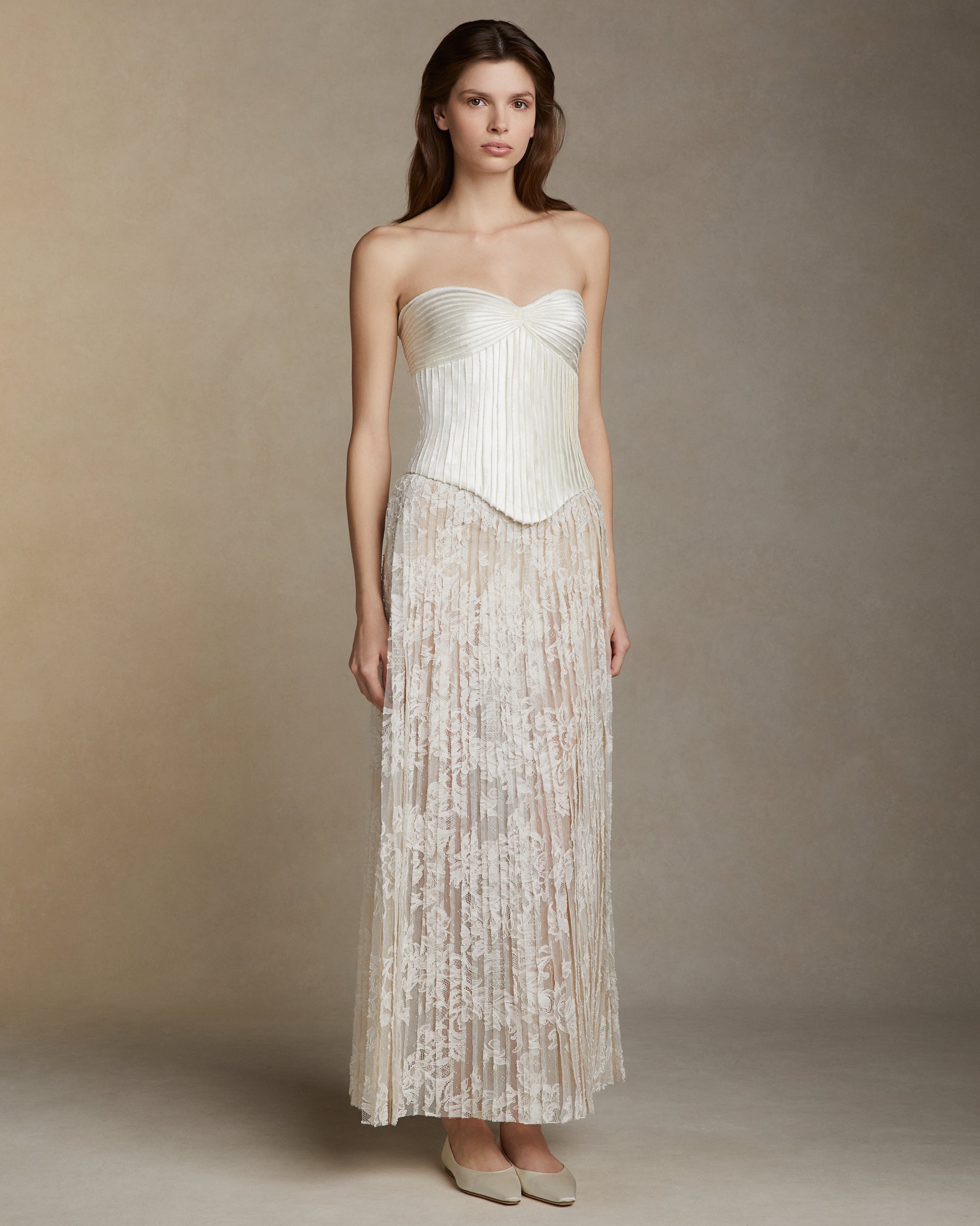 Hand cut Lyon lace strip fabric technique skirt. Layers of Lyon lace strips cascade organically into a soft A line silhouette. Invisible zip closure at center back.Styled with Ella bustier