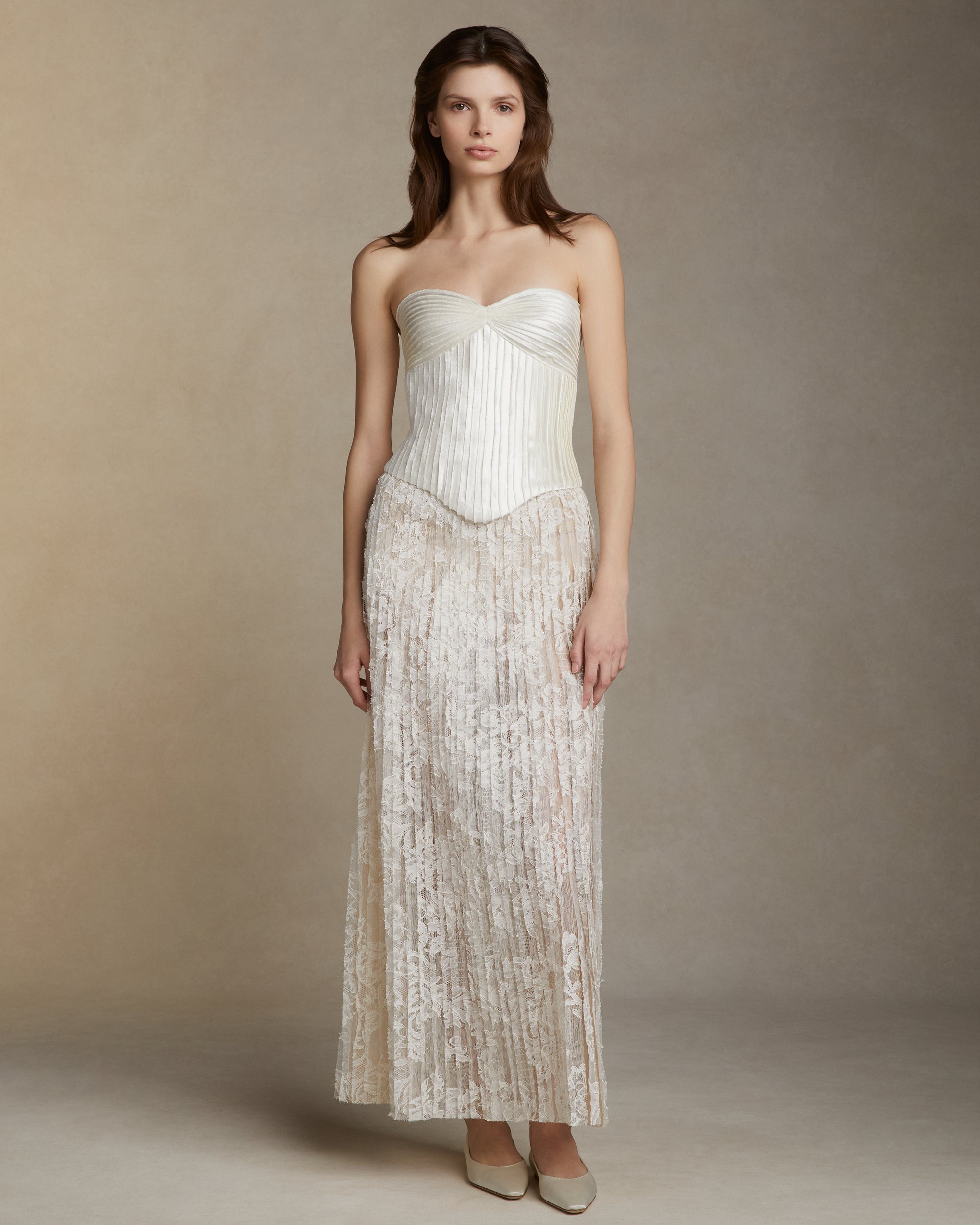 Hand cut Lyon lace strip fabric technique skirt. Layers of Lyon lace strips cascade organically into a soft A line silhouette. Invisible zip closure at center back.Styled with Ella bustier