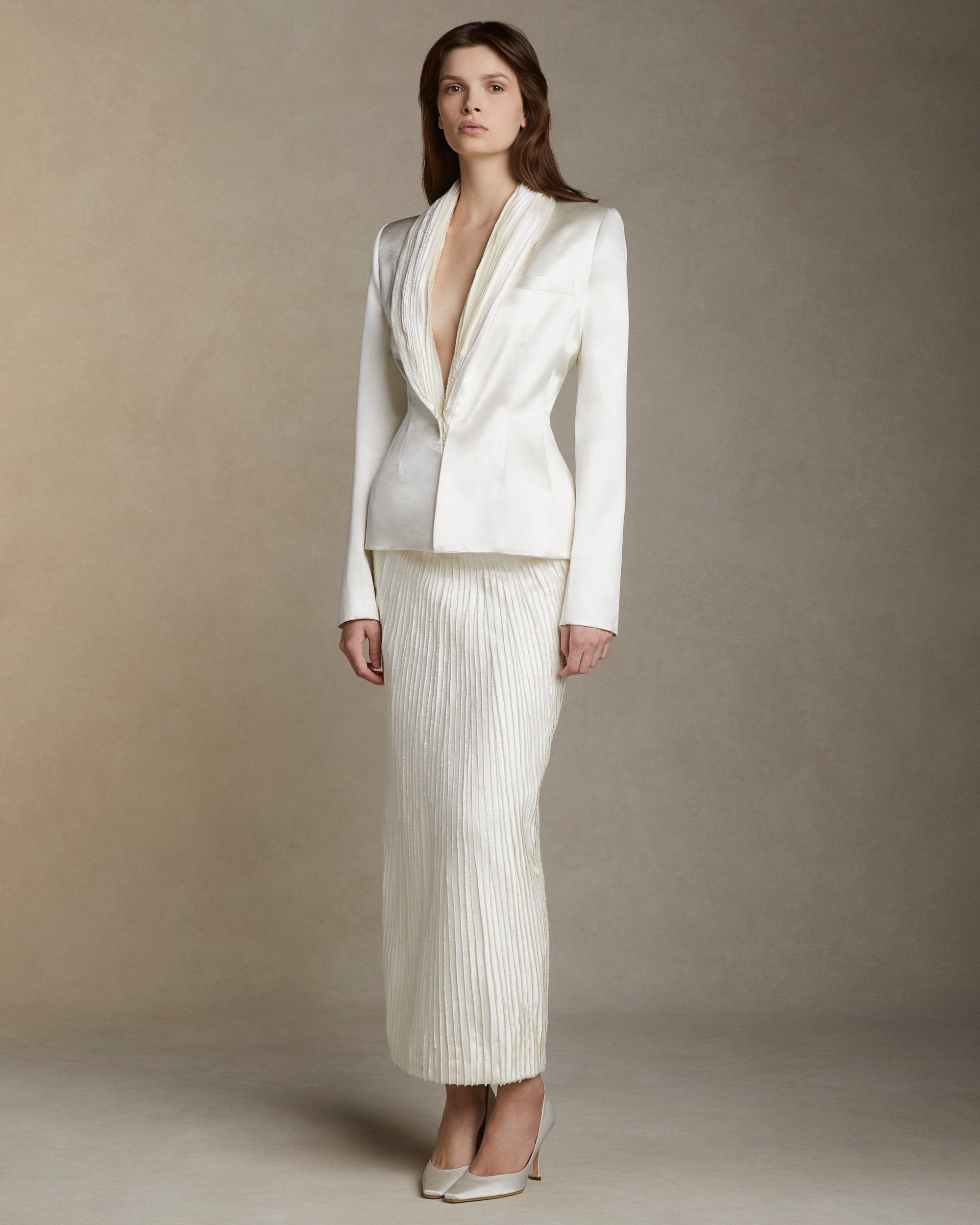 Silk wool jacket with hand cut and hand frayed bias silk wool strip lapel. Tailored nipped waist and structured hip shape. Welt  pocket at bust and single link closure at center front.Styled with Gia skirt