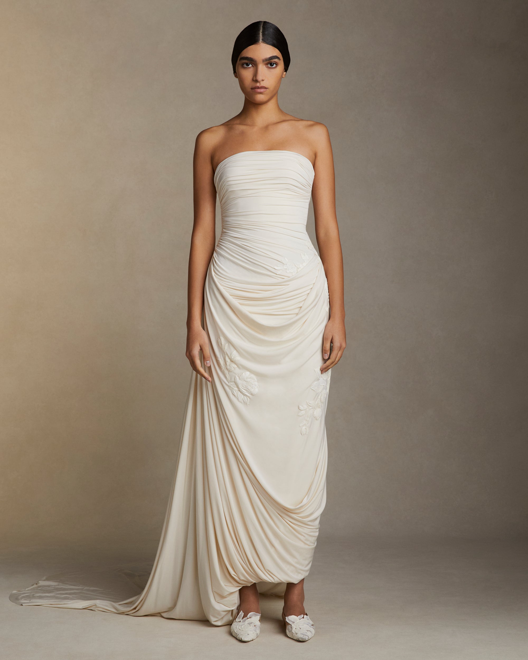Fluid jersey strapless gown with asymmetric cascading drape and hand painted floral motifs throughout. Puddle train detail. Invisible zip closure at center back.