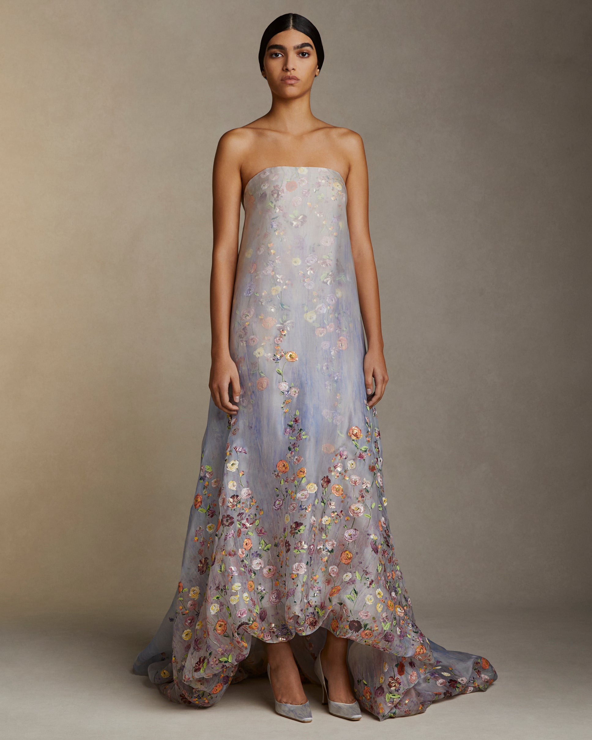 Strapless double layered silk organza gown with bubbled hem train. Printed watercolor effect and hand painted florals degrade softly up the body. Invisible zip closure at center back.