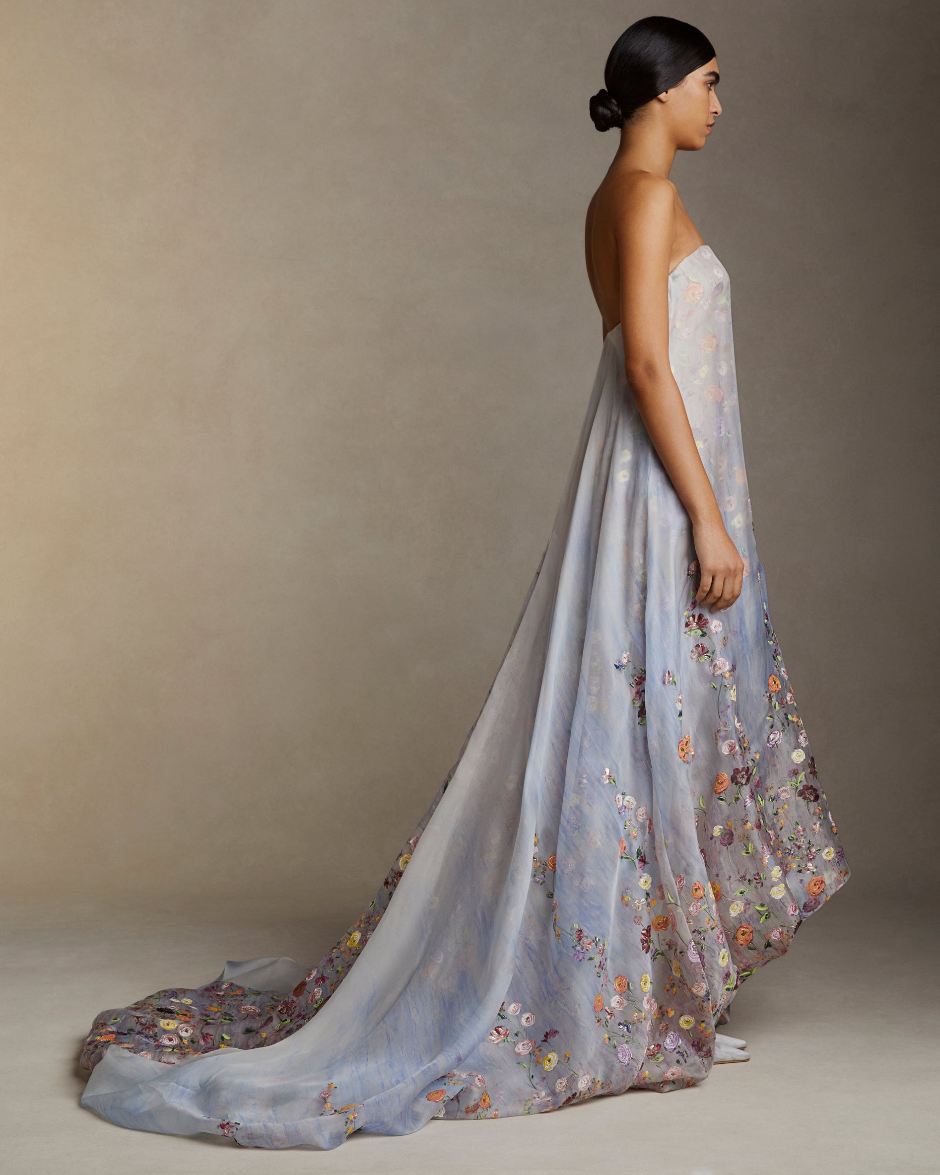 Strapless double layered silk organza gown with bubbled hem train. Printed watercolor effect and hand painted florals degrade softly up the body. Invisible zip closure at center back.