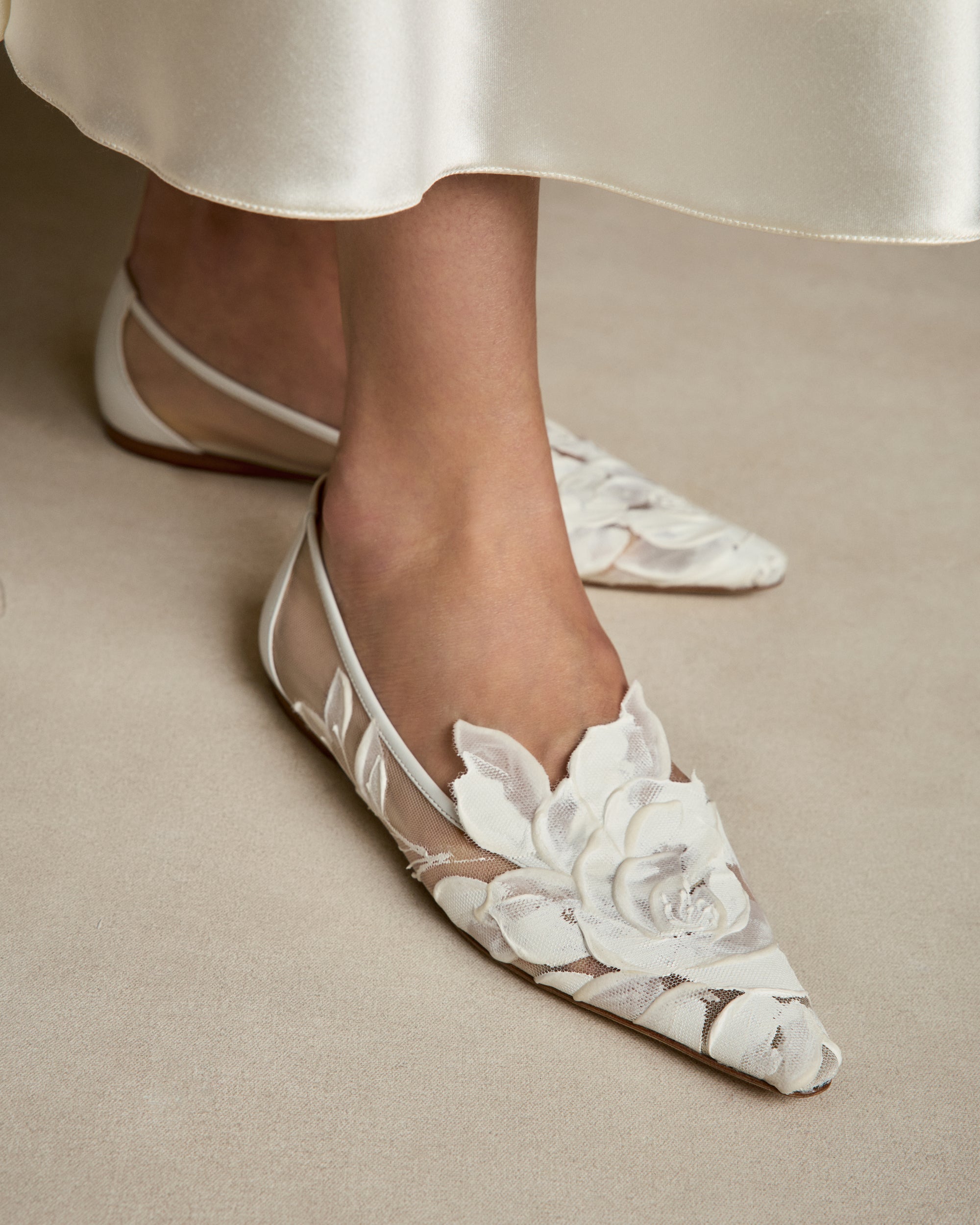 Mesh ballerina flat crafted in Italy with hand painted ivory floral detail. Elongated round toe, tonal piped leather top edge, and covered heel.