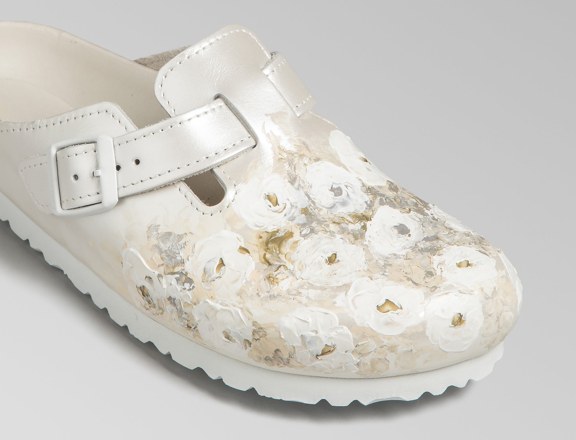 The iconic Boston is updated in an ivory pearlized finish leather with powder coated ivory buckle. Bespoke hand painted florals decorate the leather upper. Hand crafted in Germany and hand painted in France. Exclusively available through Danielle Frankel Studio.- Upper: Delicate satin upper, piped trim edge detail for premium tuxedo like finish- Footbed: Anatomical shaped BIRKENSTOCK cork latex Footbed lined with premium Nappa Leather- Sole: EVA die cut outsole with a custom design, blending classic BIRKENSTOCK bone pattern with delicate leaf inspired detailing 