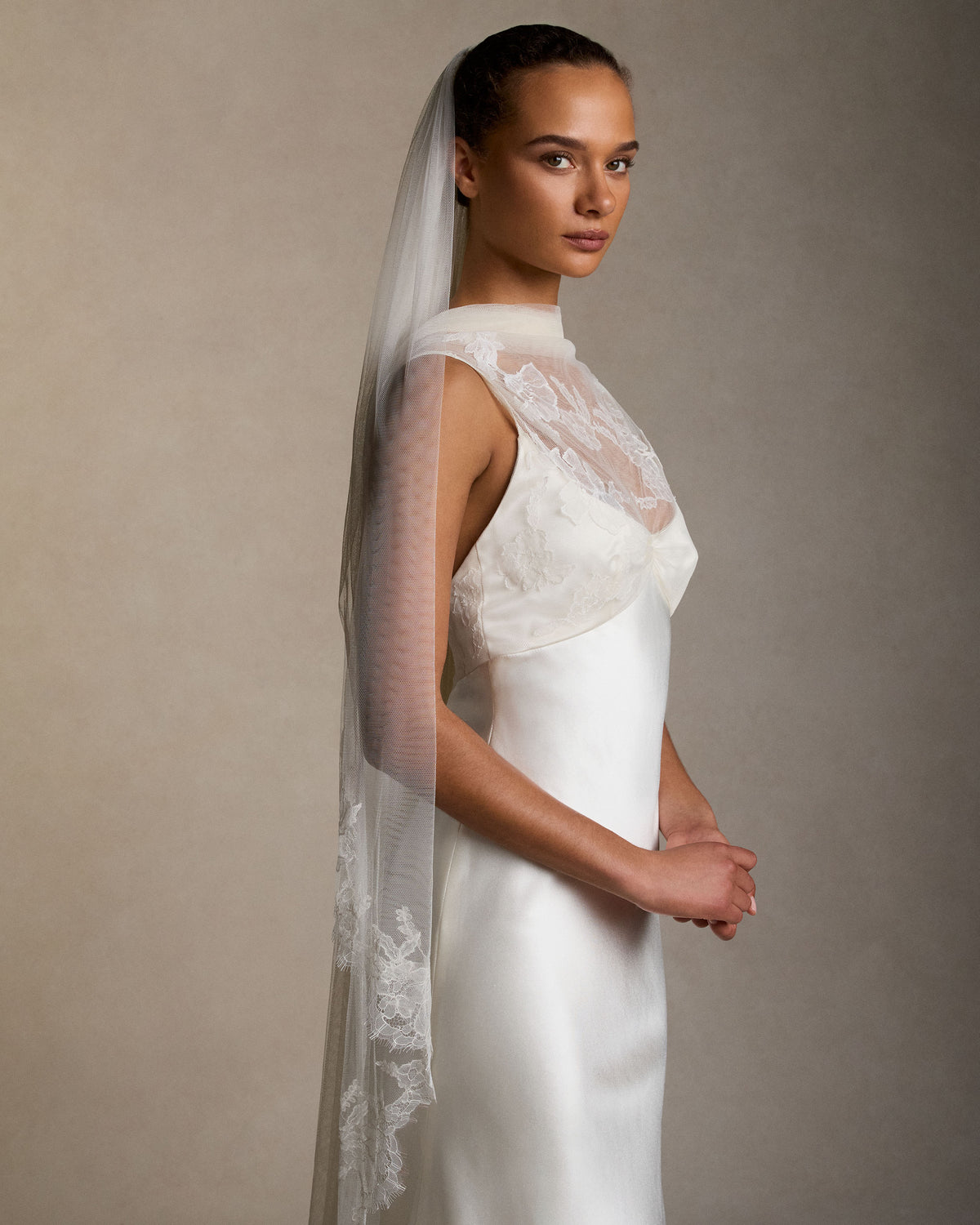 Soft tulle veil gathered into comb with hand cut Chantilly lace border detail.110” from comb to hem with 28