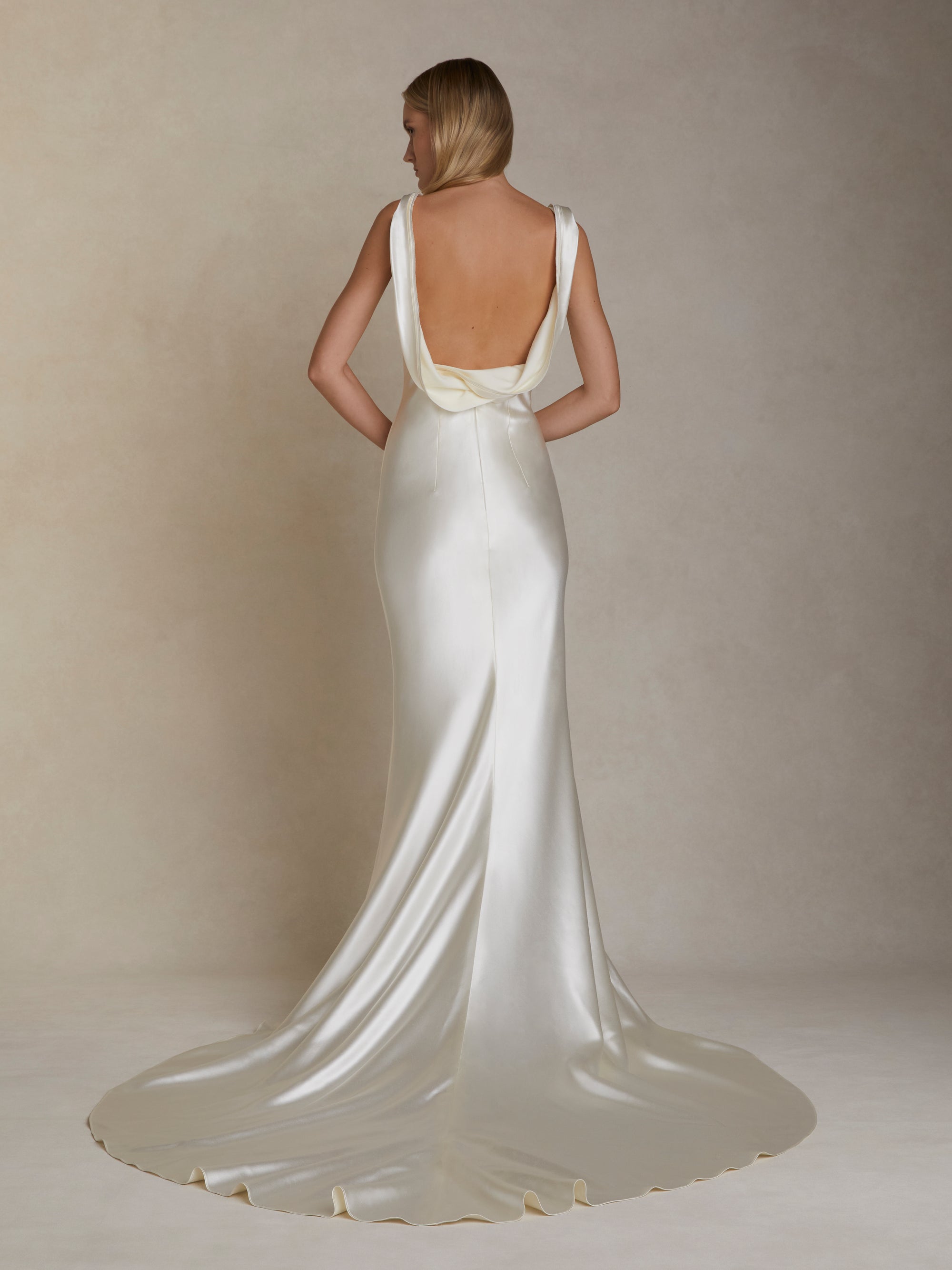 Bias cut silk wool gown with layered ribbon trim detail peeling away from neckline and trailing down back. Invisible zip closure at center back.