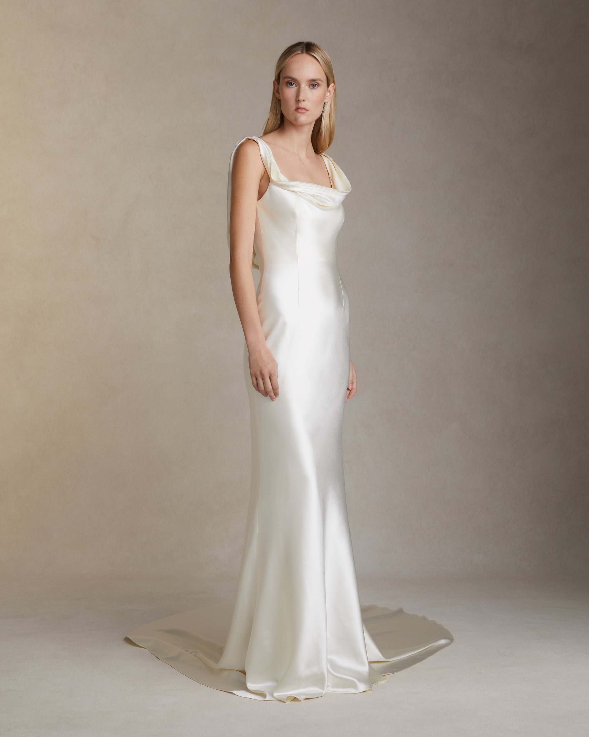 Bias cut silk wool gown with layered ribbon trim detail peeling away from neckline and trailing down back. Invisible zip closure at center back.