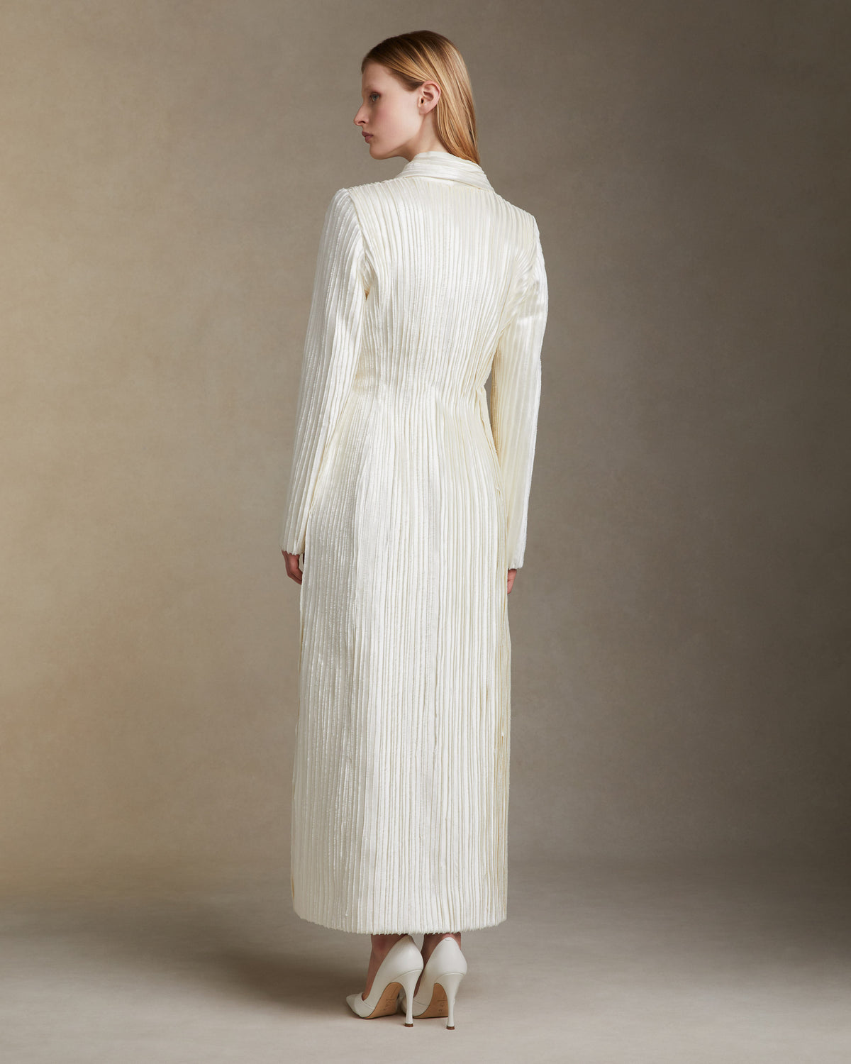 Tailored coat decorated with hand cut and hand frayed bias silk wool strip fabric technique embroidery. Nipped waist and structured hip shape. Side seam pockets and single snap closure at center front.