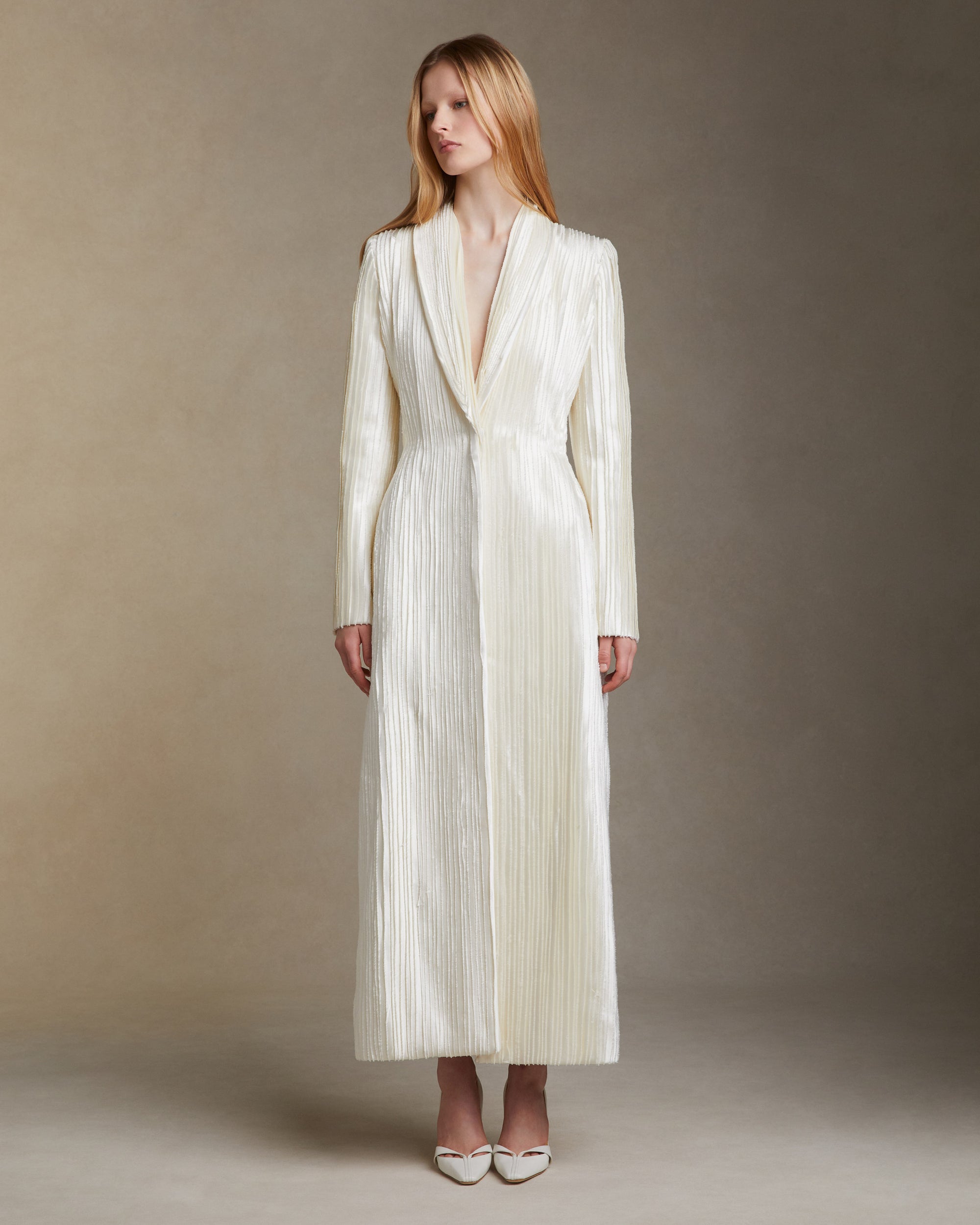 Tailored coat decorated with hand cut and hand frayed bias silk wool strip fabric technique embroidery. Nipped waist and structured hip shape. Side seam pockets and single snap closure at center front.