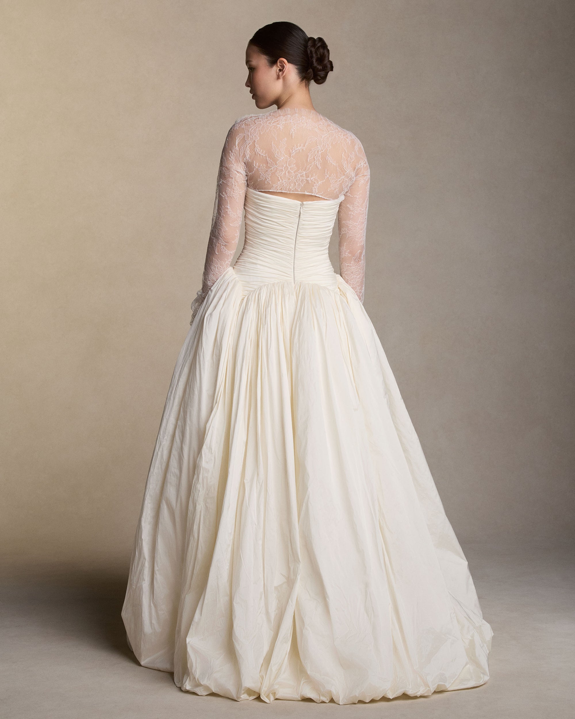 Strapless tissue taffeta ball gown with hand draped bodice and piqued waistline. Relaxed ball skirt silhouette with bubbled hem. Boned internal bustier, internal grosgrain belt and invisible zip closure at center back.Styled with Rebecca topper