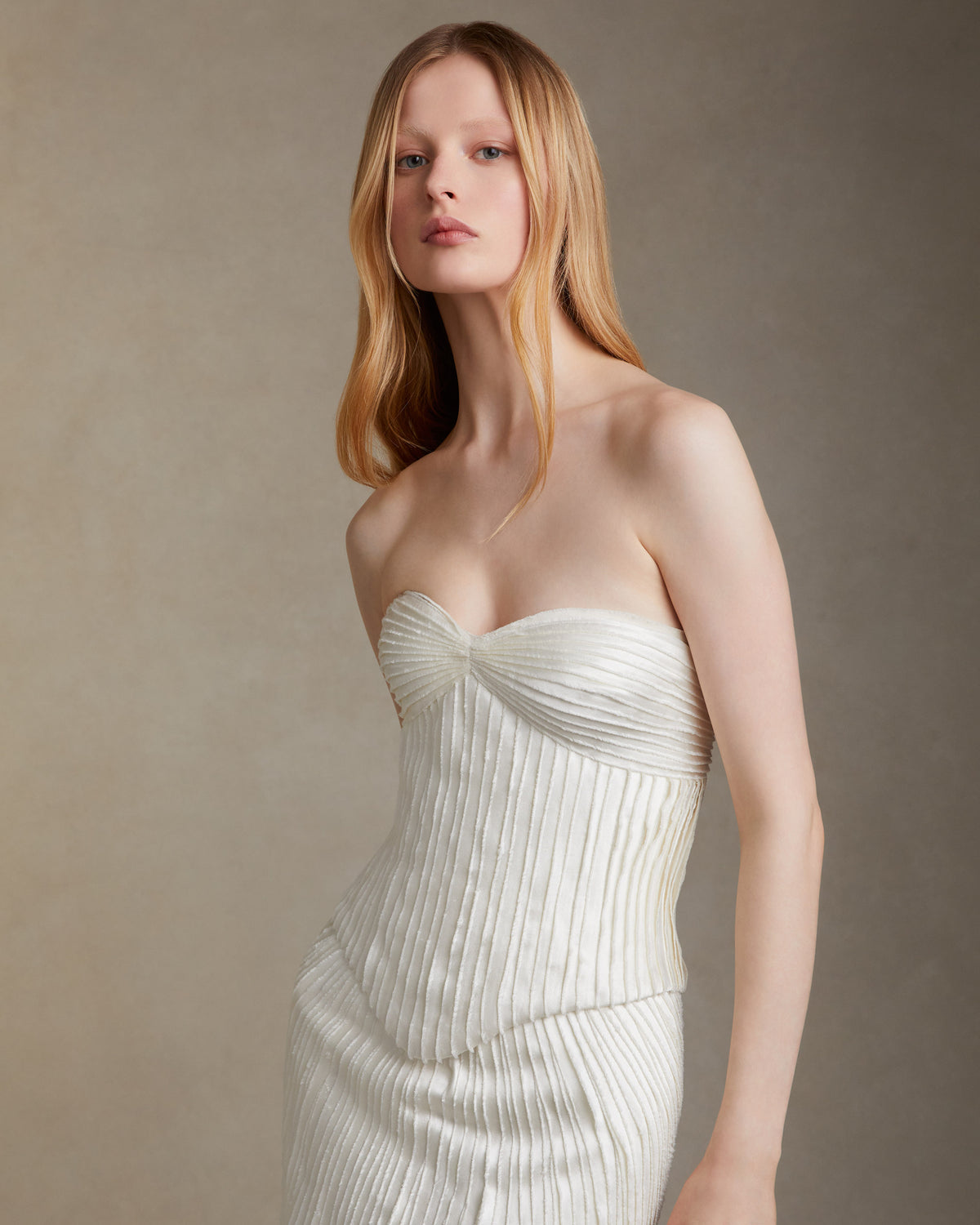 Strapless basque waist bodice decorated with hand cut and hand frayed bias silk wool strip fabric technique embroidery. Invisible zip closure at center back.Styled with Dree skirt & Gia skirt