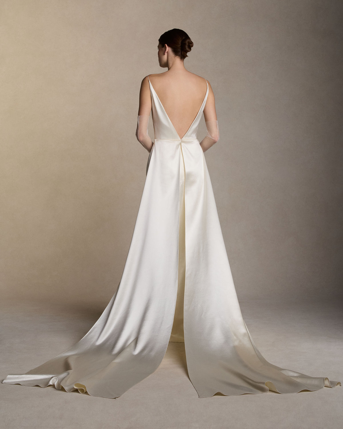 Silk wool column gown with high square neck and deep V back suspended from delicate spaghetti straps. Column skirt features dramatic side slit and removable split train detail releasing from back waist. Invisible zip closure at center back.