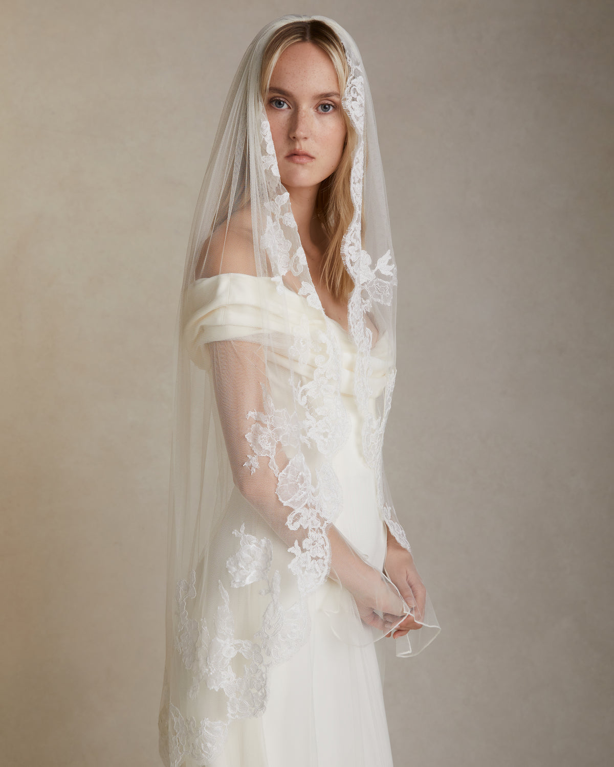 Soft tulle veil with hand cut & appliquéd corded and Chantilly lace border. Tulle is gathered into comb and extends 45