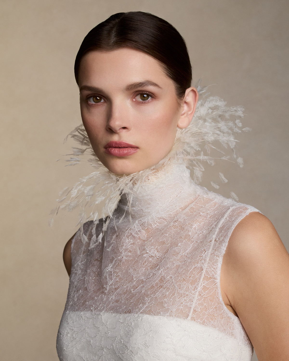 High neck sleeveless chantilly lace gown with covered button closure at center back. Layers of delicate chantilly lace finish in scalloped edge detail at neck with self fabric covered buttons down center back. Soft internal bustier with invisible zip closure at center back.