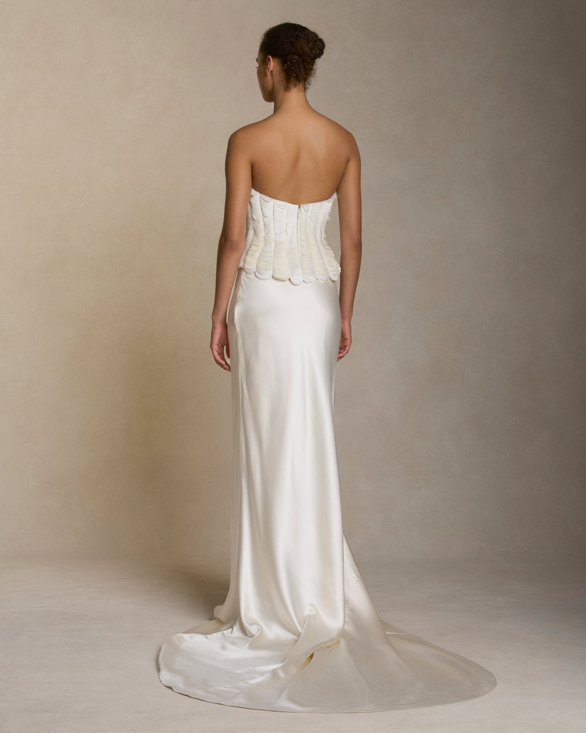 Structured bustier with thousands of layered satin petals shaping the flared neckline silhouette. Boned internal bustier, internal grosgrain belt and invisible zip closure at center back.Styled with Dree skirt & Tess skirt