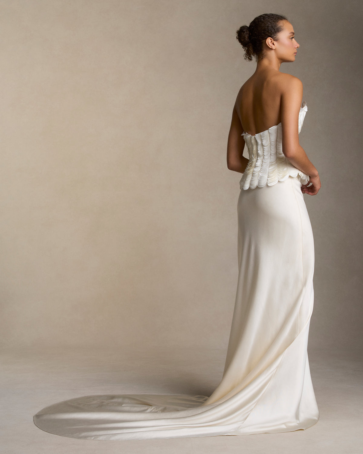 Structured bustier with thousands of layered satin petals shaping the flared neckline silhouette. Boned internal bustier, internal grosgrain belt and invisible zip closure at center back.Styled with Dree skirt & Tess skirt