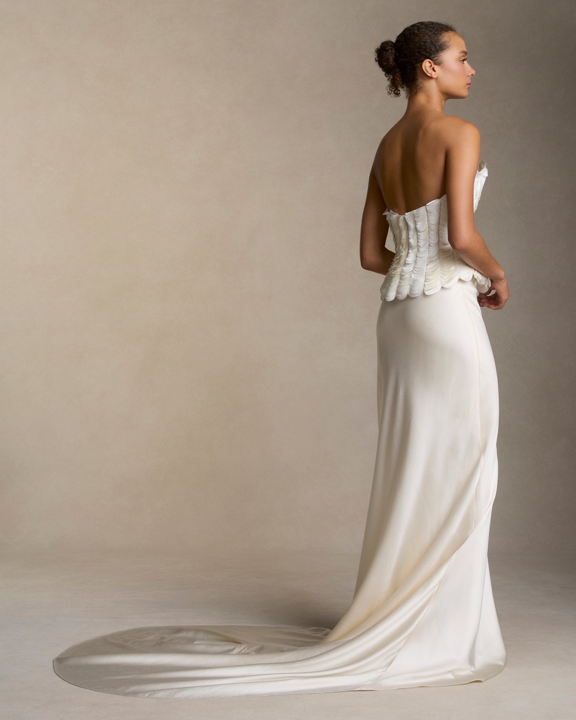 Structured bustier with thousands of layered satin petals shaping the flared neckline silhouette. Boned internal bustier, internal grosgrain belt and invisible zip closure at center back.Styled with Dree skirt &amp; Tess skirt