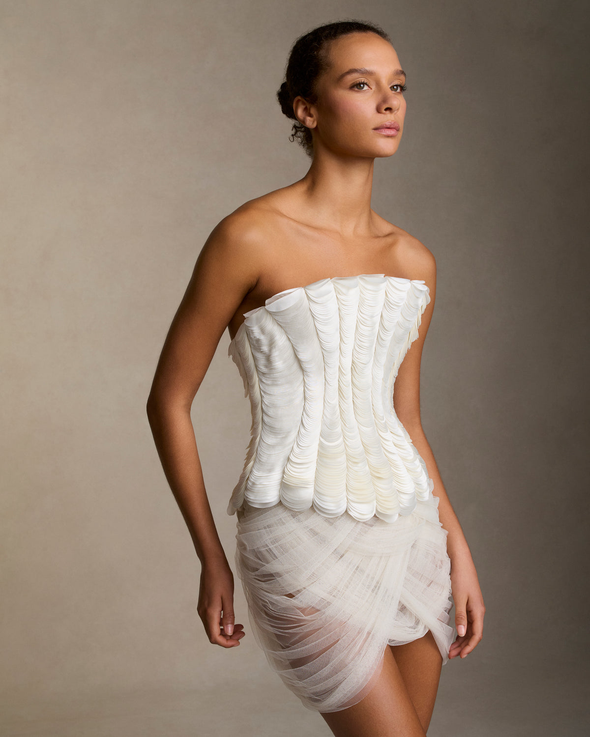 Soft tulle mini skirt with layered interlocking swag drapes cascading from waist. Invisible side zip closureStyled with Inez bustier