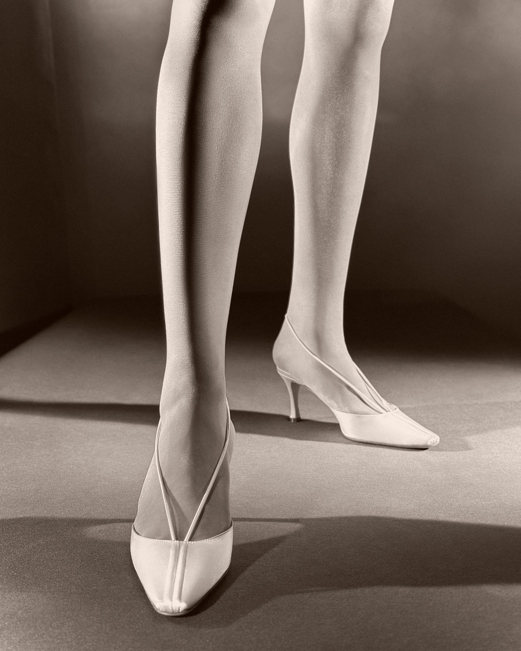 70mm rounded square toe mule crafted in Italy of ivory satin. Elastic sling back wraps around the foot, finishing into a channel detail at toe.