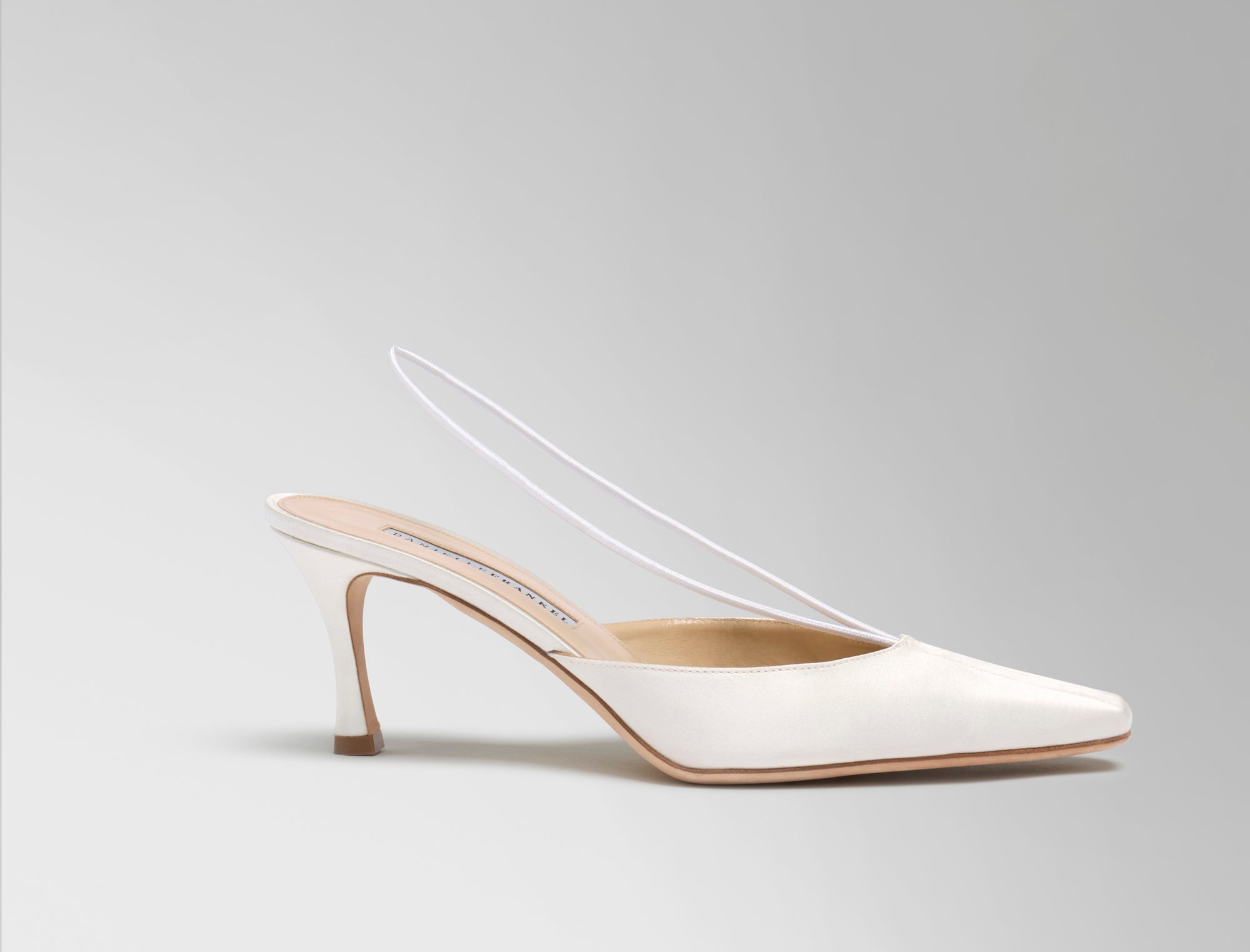 70mm rounded square toe mule crafted in Italy of ivory satin. Elastic sling back wraps around the foot, finishing into a channel detail at toe.