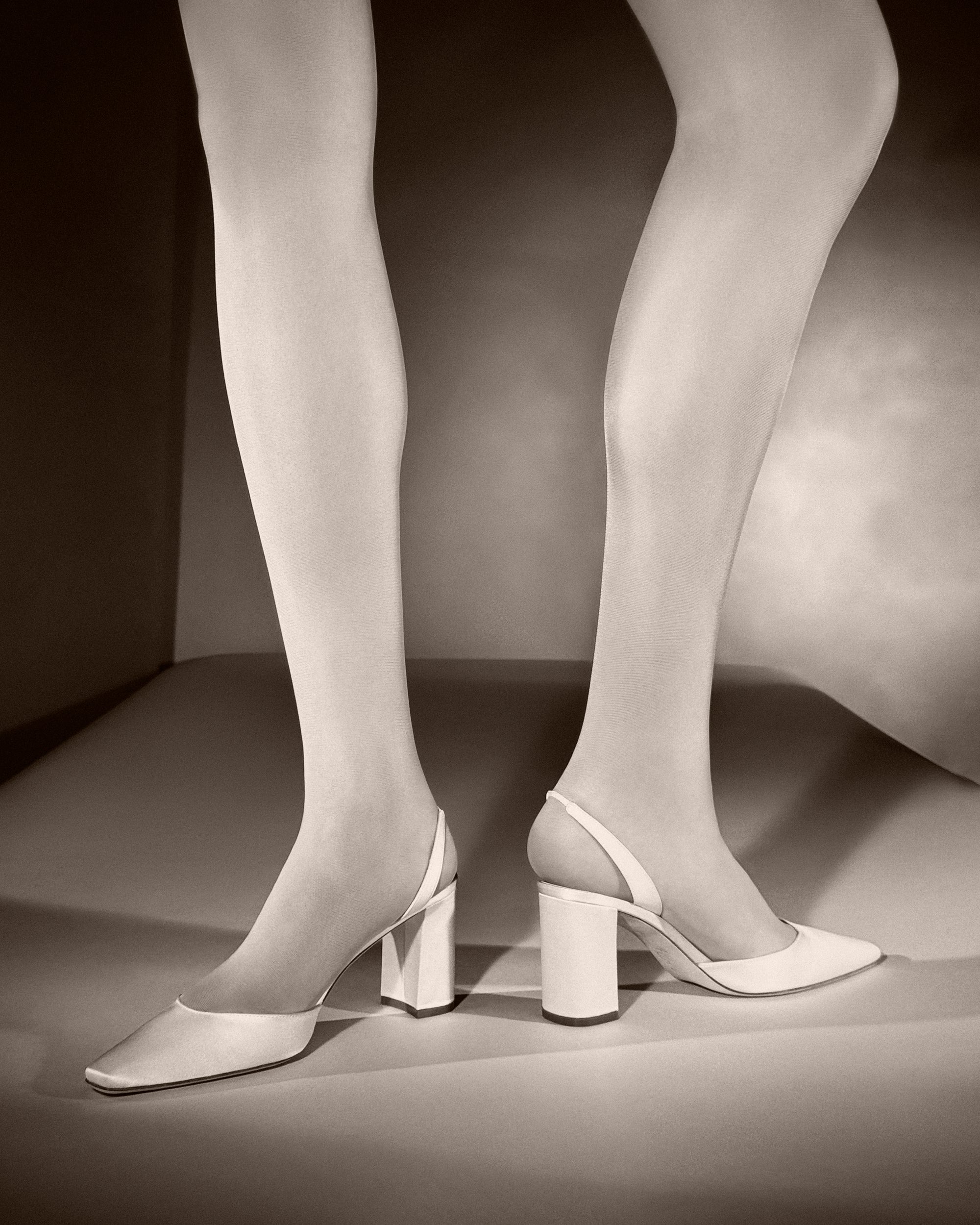 Classic rounded square toe slingback crafted in Italy of ivory satin. 75mm block heel.