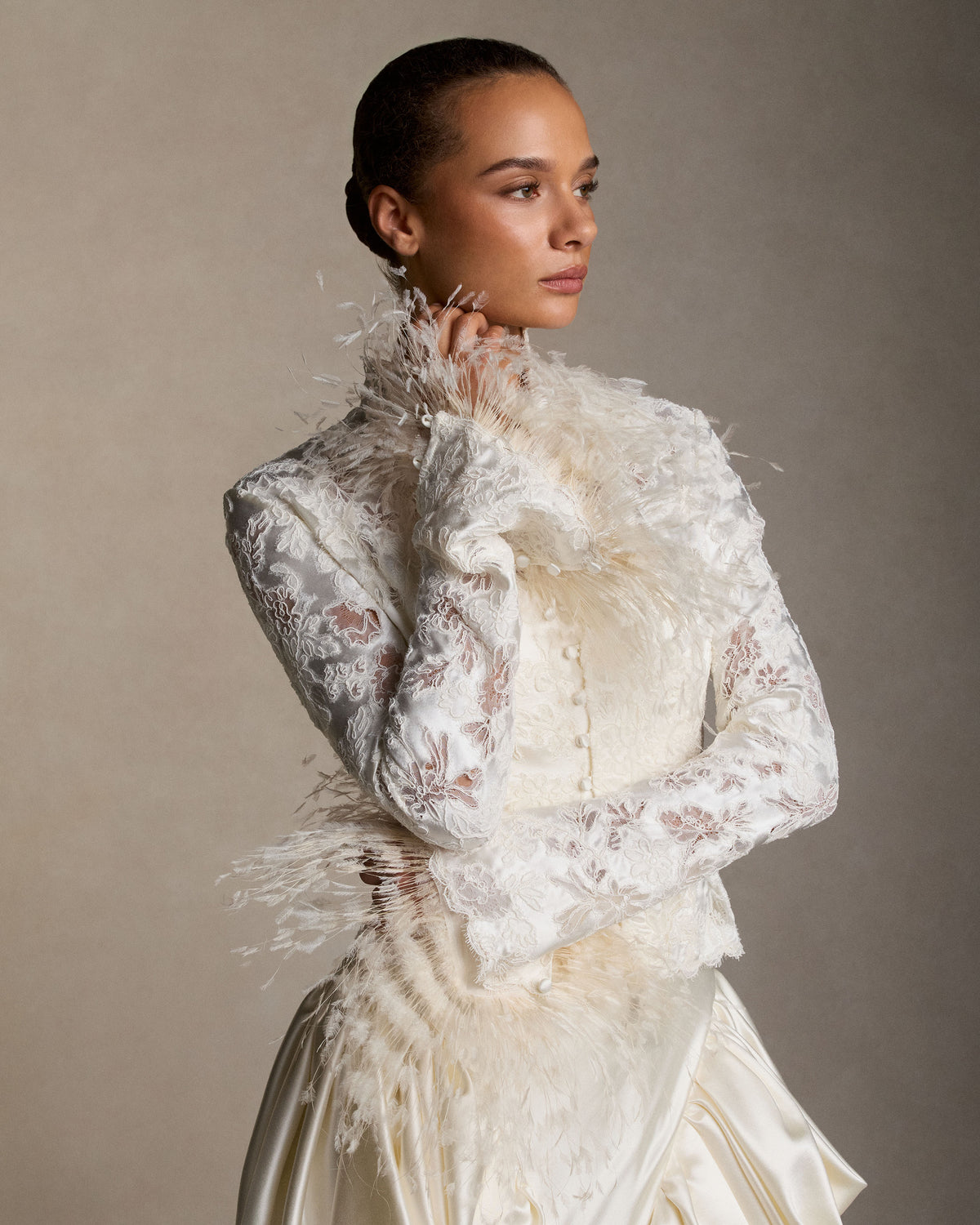 Organza sleeve cuffs with trimmed ostrich feather trim. Covered button and elastic loop closure. 