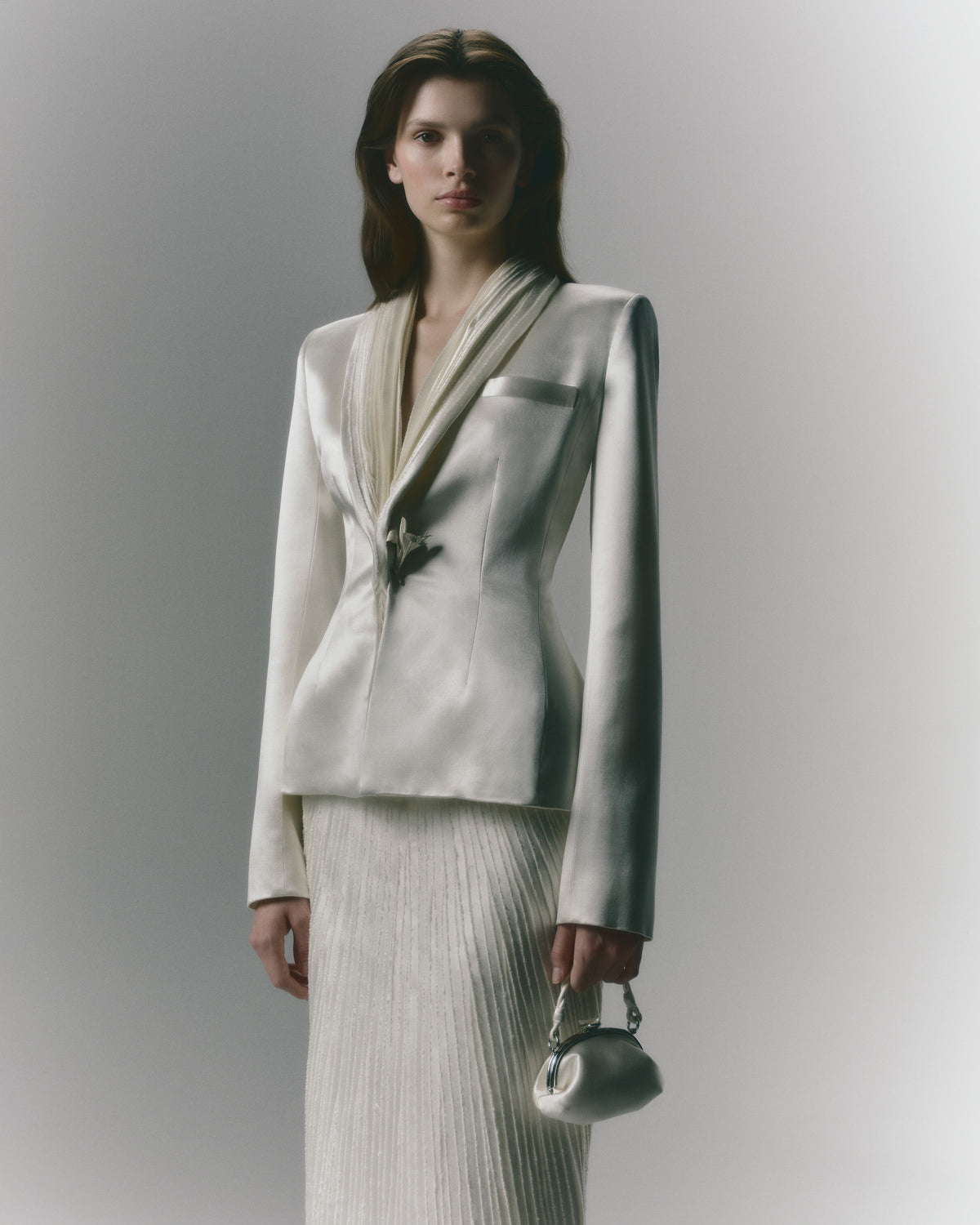 Silk wool jacket with hand cut and hand frayed bias silk wool strip lapel. Tailored nipped waist and structured hip shape. Welt  pocket at bust and single link closure at center front.Styled with Gia skirt
