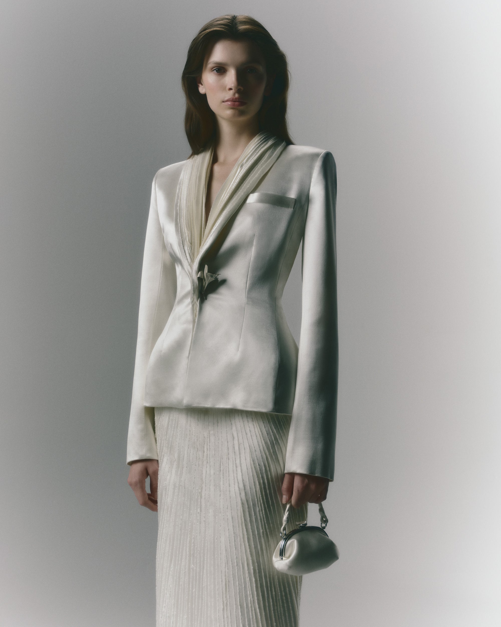 Silk wool jacket with hand cut and hand frayed bias silk wool strip lapel. Tailored nipped waist and structured hip shape. Welt  pocket at bust and single link closure at center front.Styled with Gia skirt