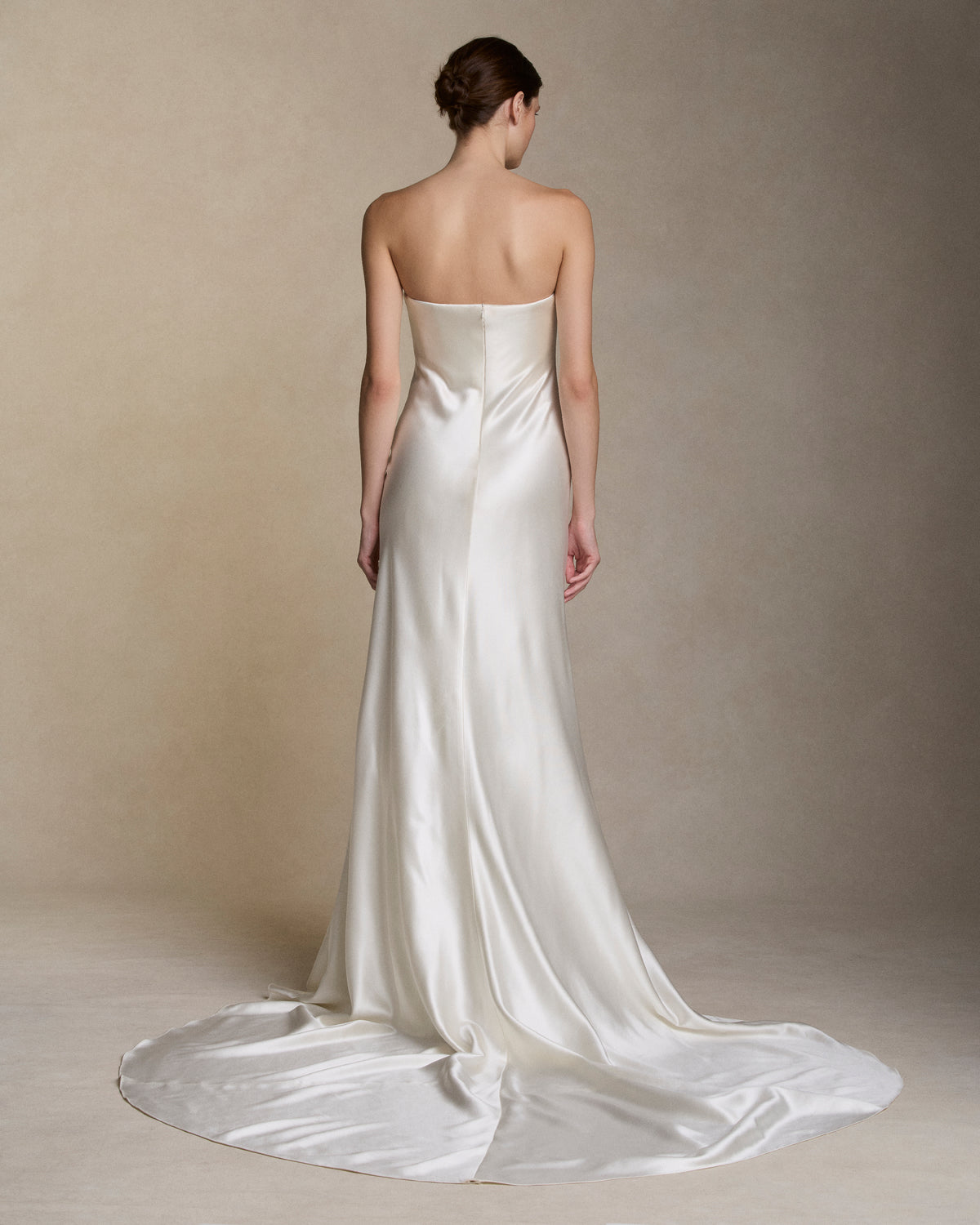 Strapless silk wool bias cut gown with hand cut silk wool petal embroidery decorating the neckline. Boned internal bustier with soft cups, internal grosgrain belt and invisible zip closure at center back.
