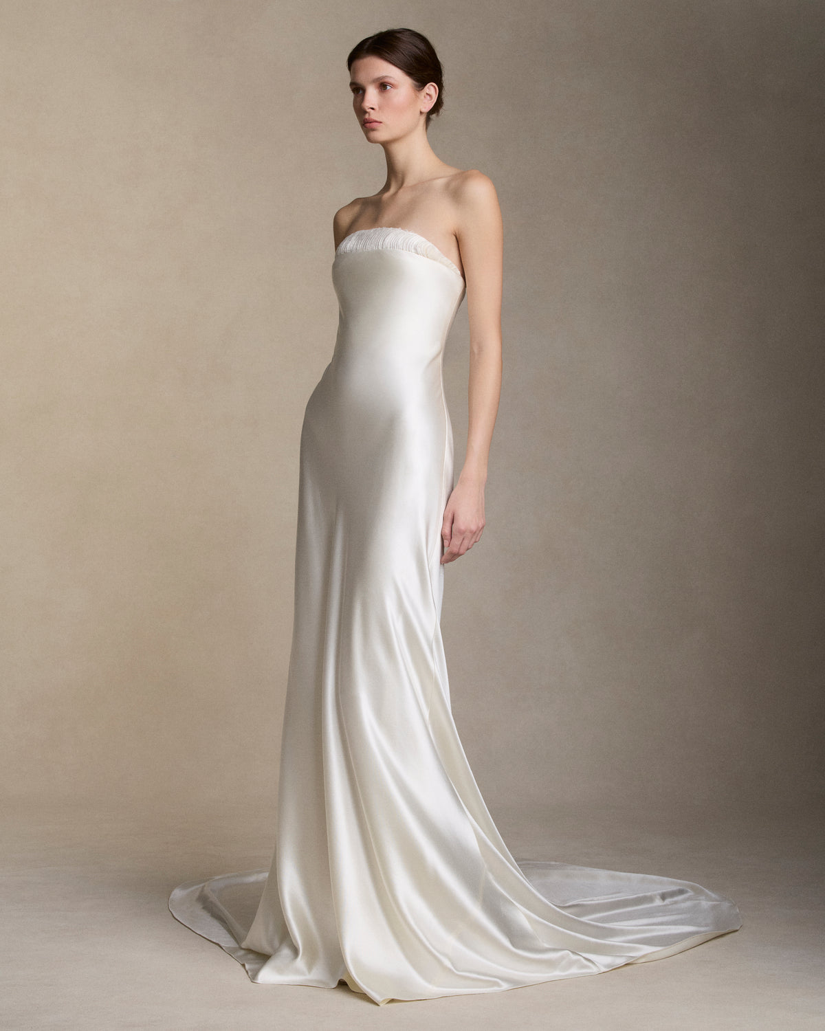 Strapless silk wool bias cut gown with hand cut silk wool petal embroidery decorating the neckline. Boned internal bustier with soft cups, internal grosgrain belt and invisible zip closure at center back.