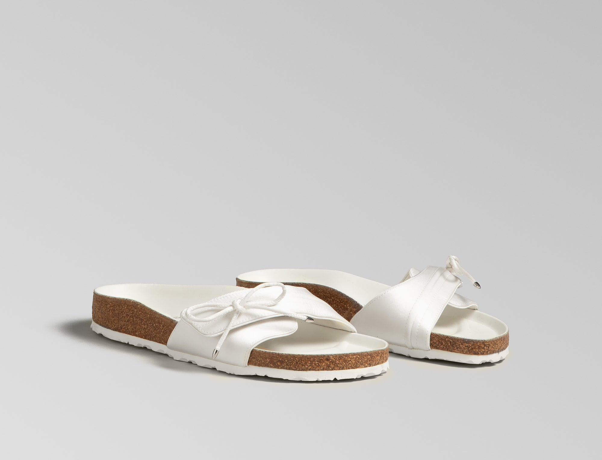 BIRKENSTOCK’s original 1963 design is reimagined by Danielle Frankel in a pure, minimalist silhouette with a delicate satin upper. A satin cord with metal-tipped ends adds refined elegance. The design also introduces an innovative adjustable hidden buckle closure, while handcrafted German craftsmanship ensures the iconic comfort and quality BIRKENSTOCK is known for. - Upper: Delicate satin upper, bow detail with metal ends- Footbed: Anatomical shaped BIRKENSTOCK cork latex Footbed lined with premium Nappa Leather- Sole: EVA die cut outsole with a custom design, blending classic BIRKENSTOCK bone pattern with delicate leaf inspired detailing