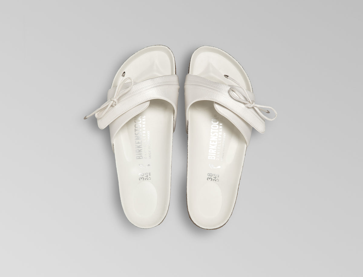 BIRKENSTOCK’s original 1963 design is reimagined by Danielle Frankel in a pure, minimalist silhouette with a delicate satin upper. A satin cord with metal-tipped ends adds refined elegance. The design also introduces an innovative adjustable hidden buckle closure, while handcrafted German craftsmanship ensures the iconic comfort and quality BIRKENSTOCK is known for. - Upper: Delicate satin upper, bow detail with metal ends- Footbed: Anatomical shaped BIRKENSTOCK cork latex Footbed lined with premium Nappa Leather- Sole: EVA die cut outsole with a custom design, blending classic BIRKENSTOCK bone pattern with delicate leaf inspired detailing