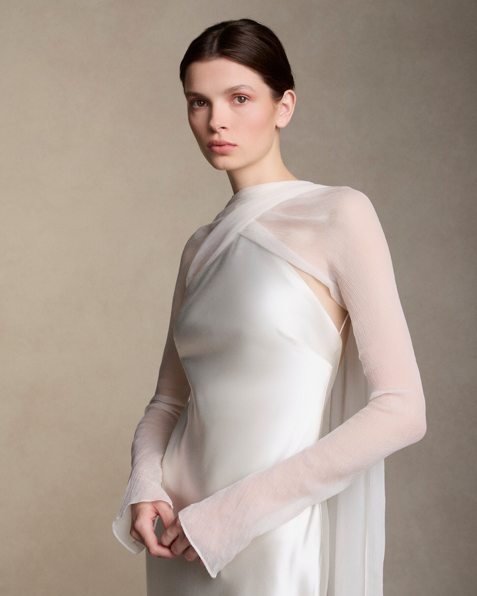 Removable tulle sleeves drape across center front falling into a scarf train detail at center back.  