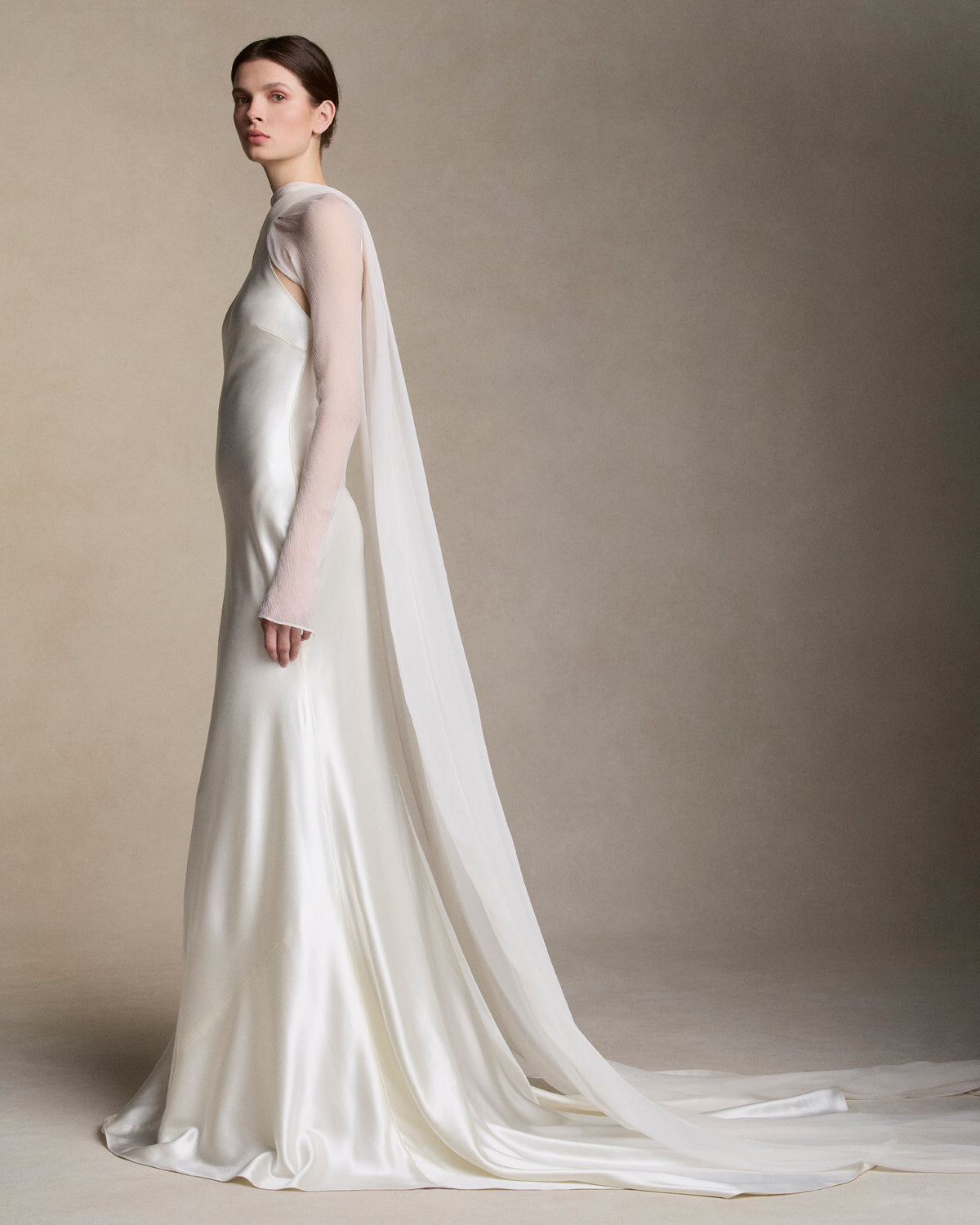 Removable tulle sleeves drape across center front falling into a scarf train detail at center back.  