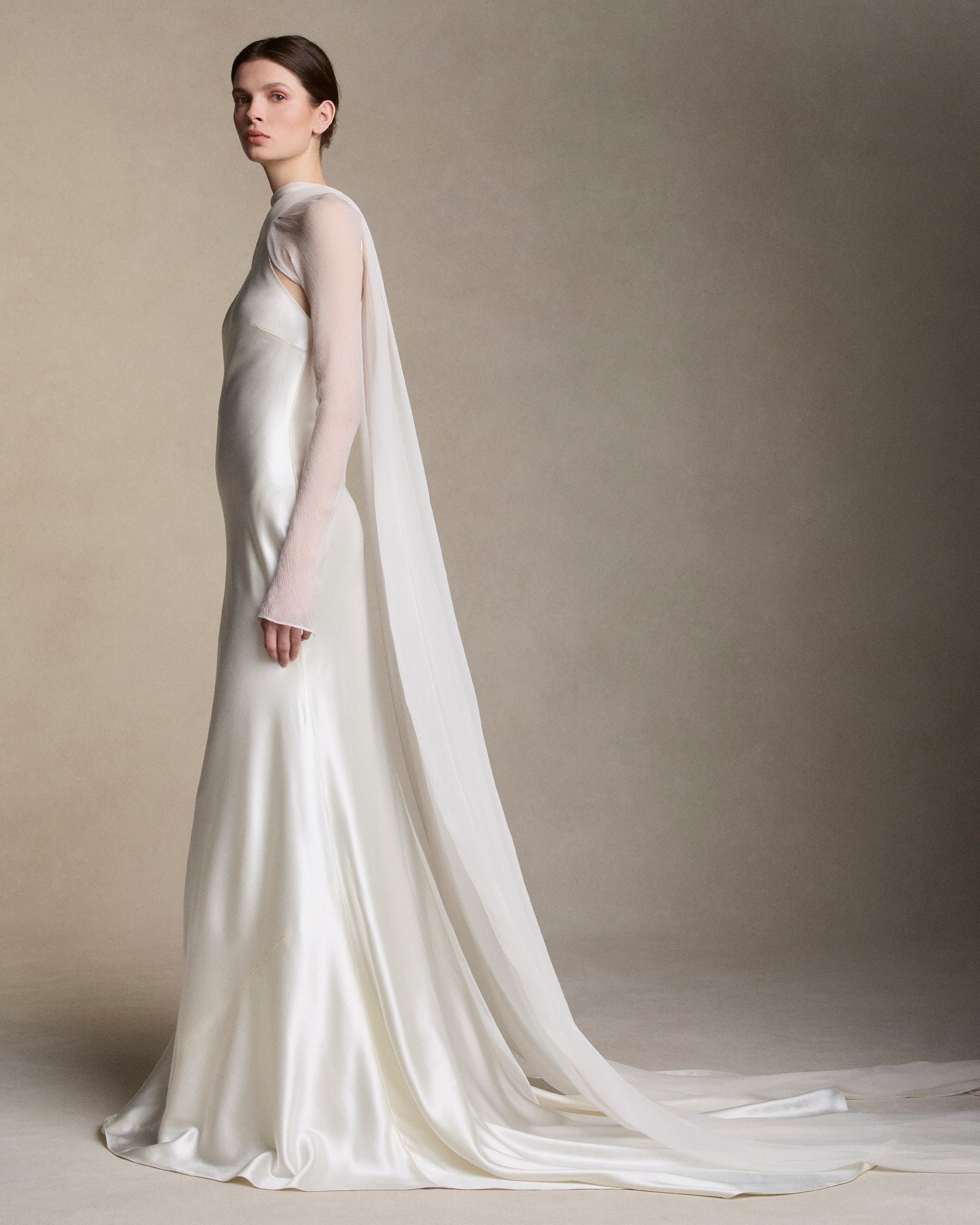Removable tulle sleeves drape across center front falling into a scarf train detail at center back.  
