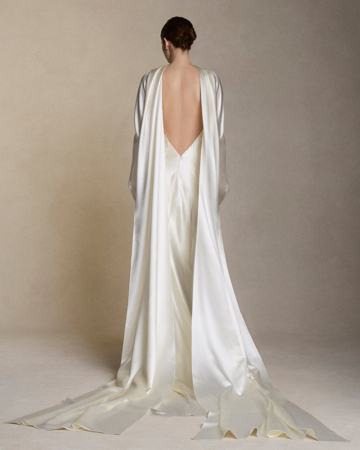 Removable tulle sleeves drape across center front falling into a scarf train detail at center back.  