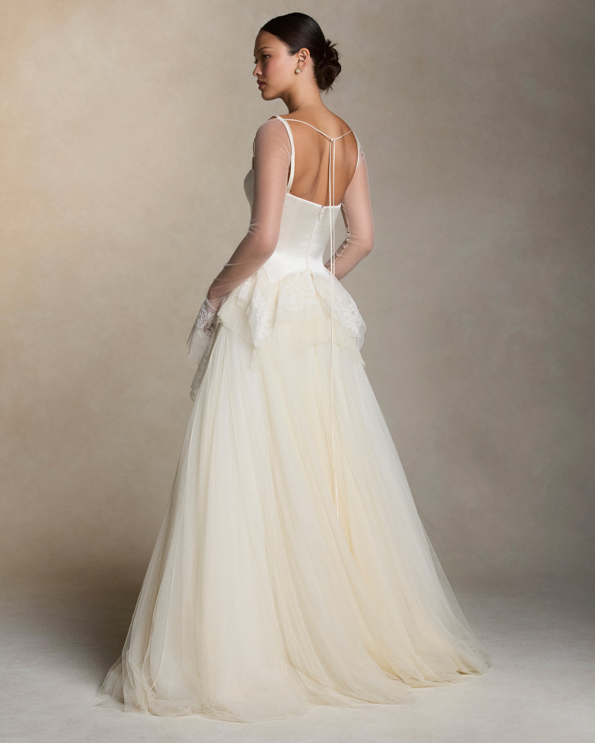 Soft tulle sleeves with bell cuff detail in Lyon lace. Silk spaghetti tie detail at center back neckline.
