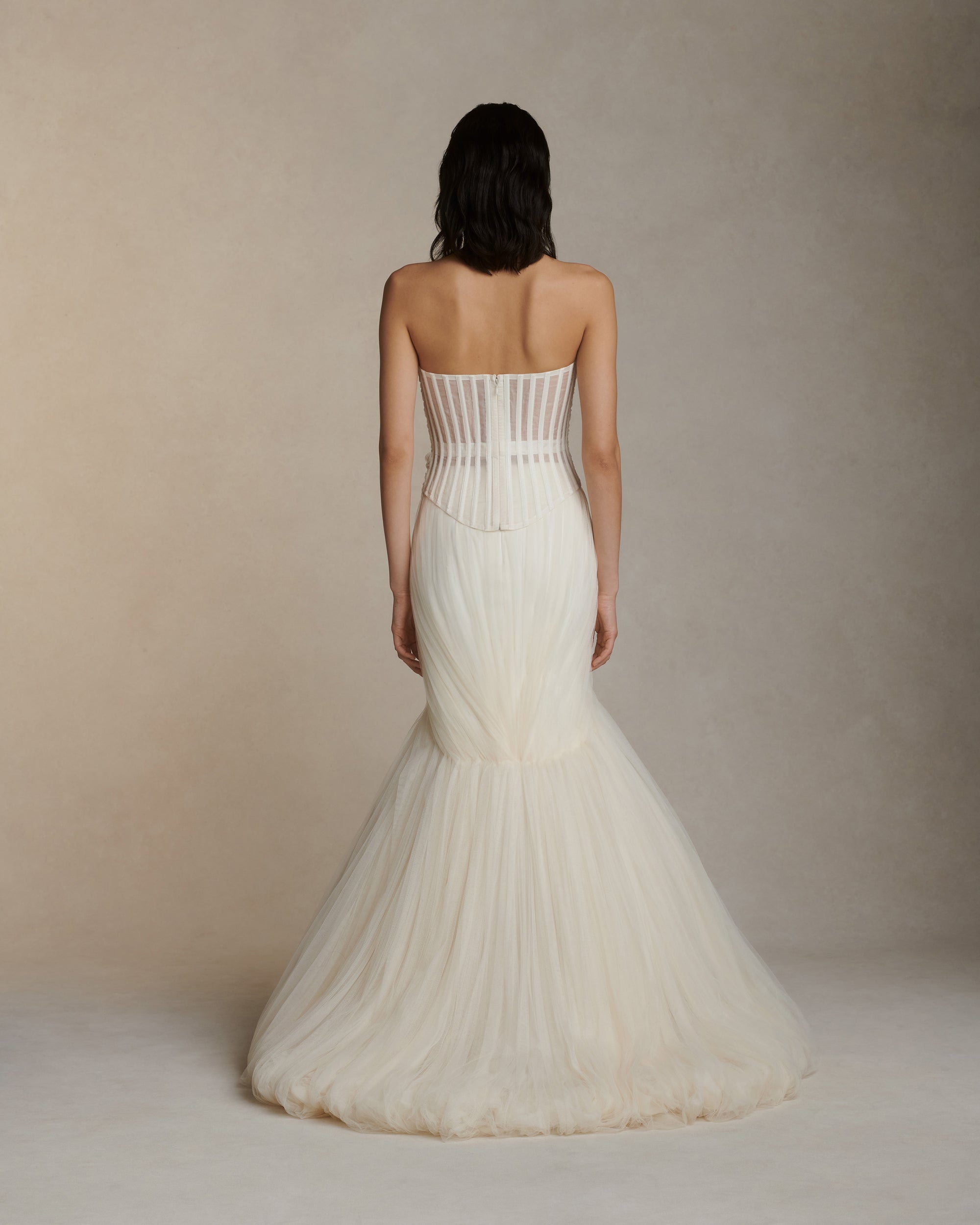 Structured corset top with dipped waist and layered soft tulle draping at front. Exposed organza bustier at back with grosgrain detail. Soft cups, internal grosgrain waist belt and invisible center back zip closure.Styled with Jack pant &amp; Jacqueline skirt 